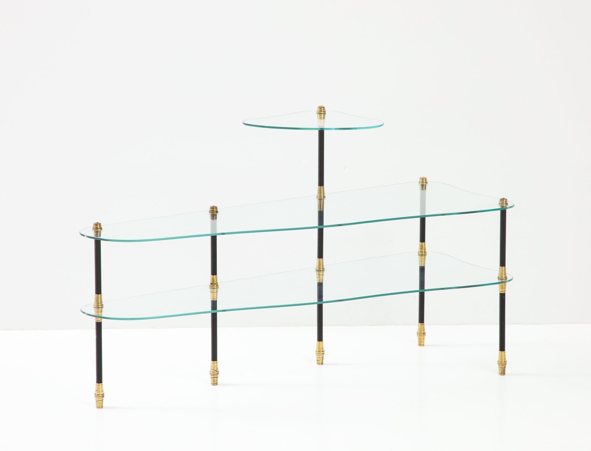 A great Maison Jansen French Modern 3-shelf glass Etagere. Jansen French Modern three-shelf diminutive etagere with amorphous glass shelves, black and gold-colored metal structure.