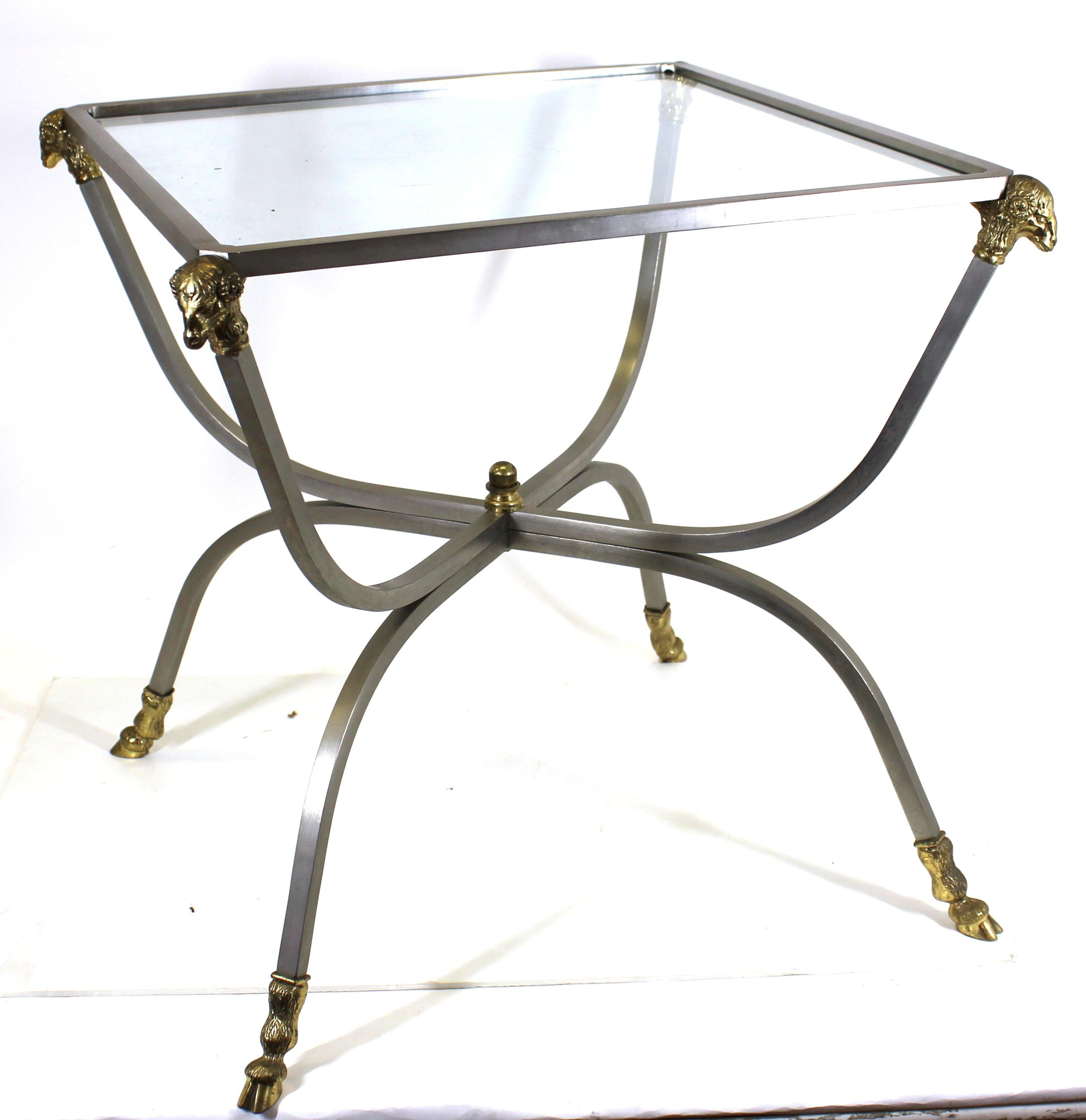Maison Jansen French Modern side table in brushed steel with brass rams heads and hooves, with glass top. 21.5