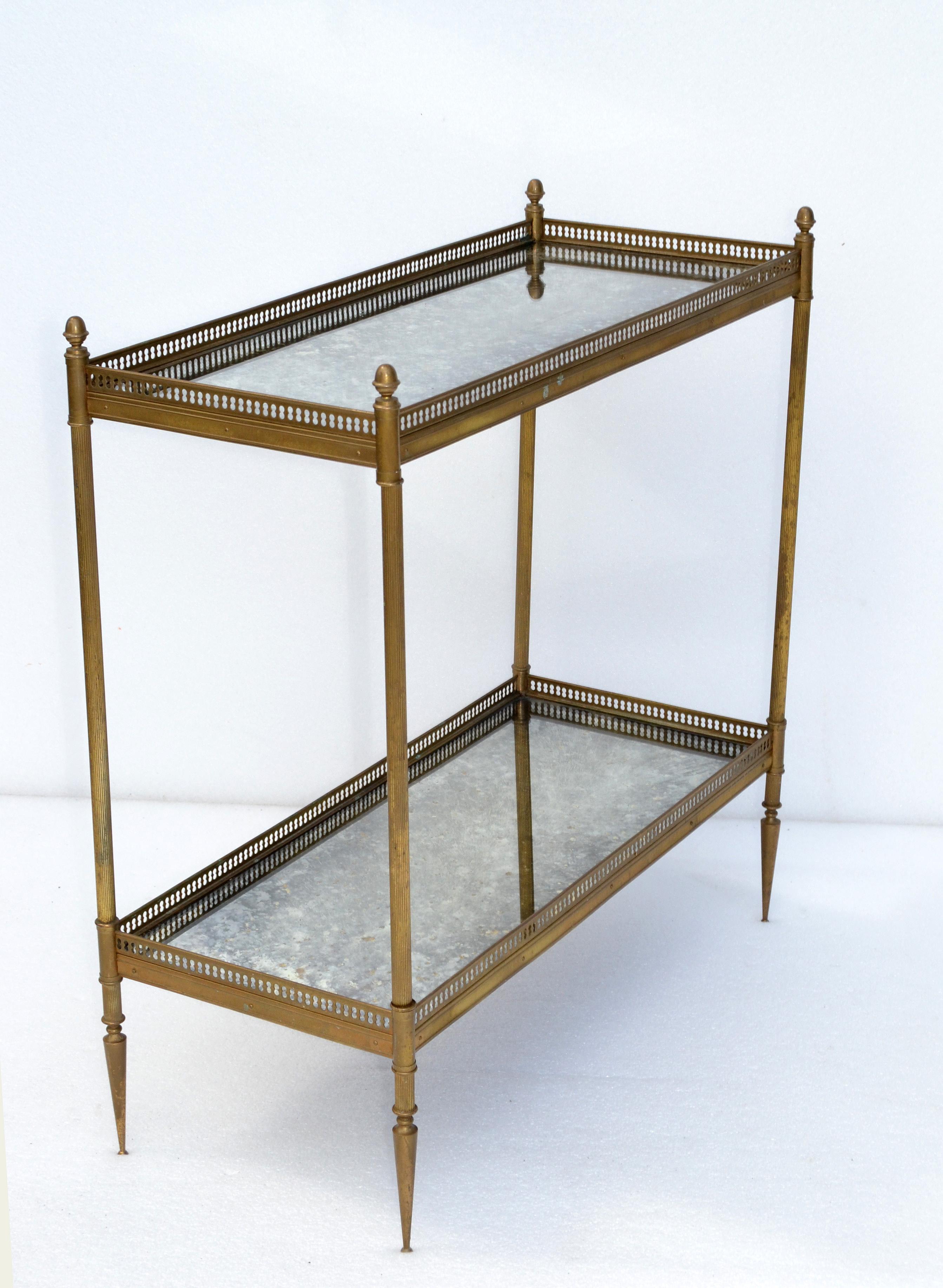 Maison Jansen brass 2-tier side table with cloudy mirror tops. 
Brass gallery and Bronze finials.
Very good vintage condition.
 