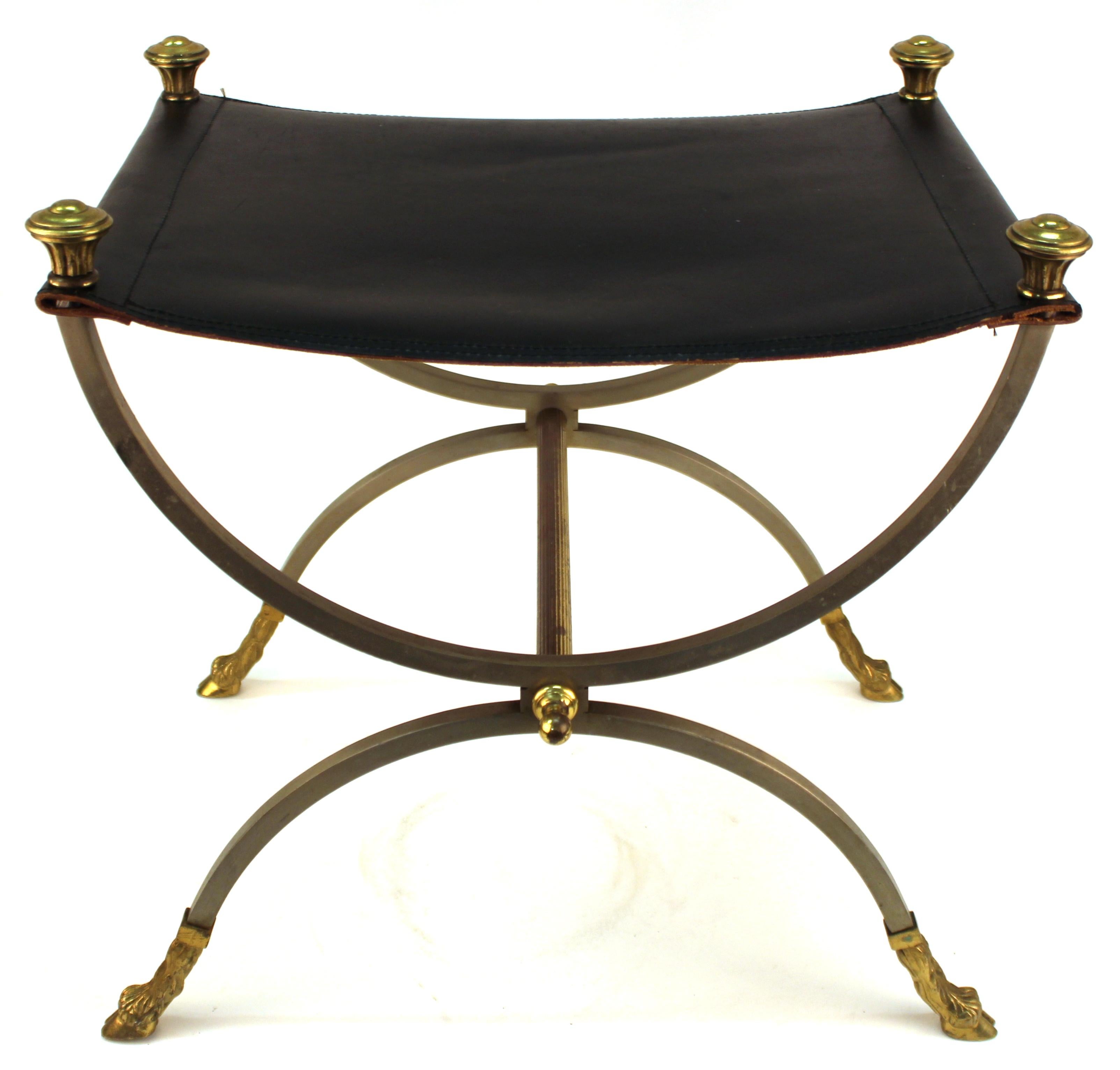 French neoclassical Revival style bench made by Maison Jansen. The piece has a metal structure with gilt decorative elements and hoofed feet and has a black leather seat. In great vintage condition with some age-appropriate wear to the leather.