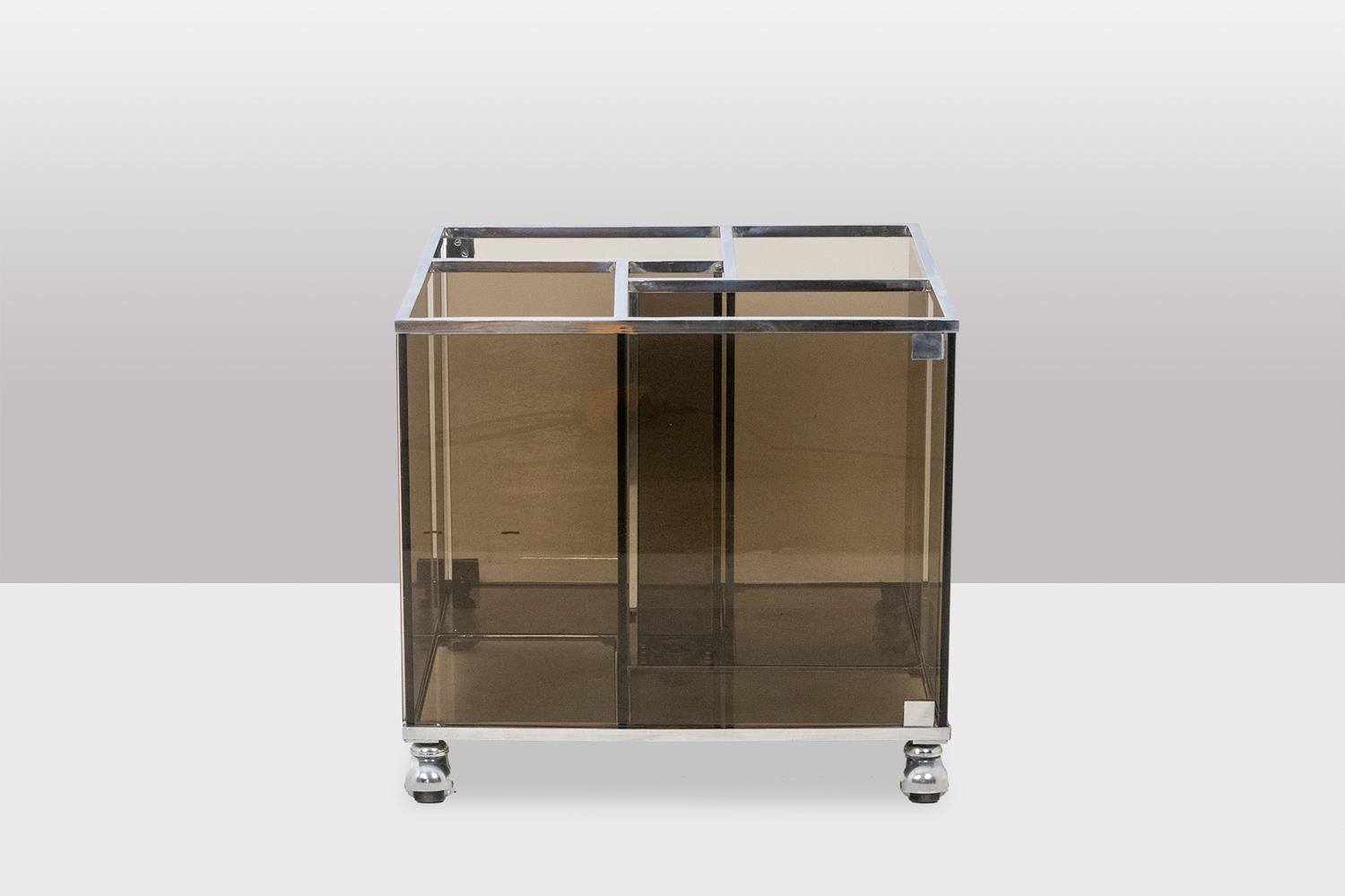 Maison Jansen, by. 

Furniture for storing vinyl records made up of smoked glass windows, with its chrome-plated metal frame and casters, opening with two doors, and designed to store 33 rpm and 45 rpm records.

French work realized in the