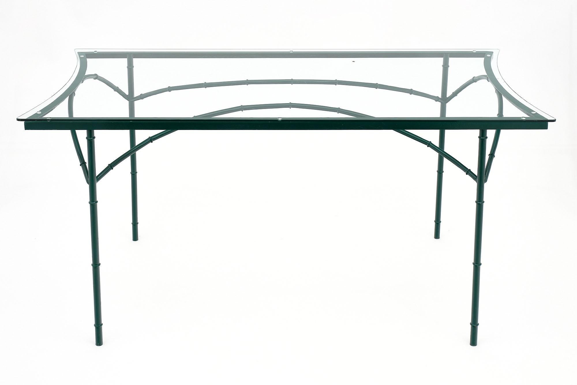 French vintage garden dining room table attributed to Maison Jansen. The structure is stylized bambou steel frame in a green tone with a curved original glass top. Some surface wear to the glass.