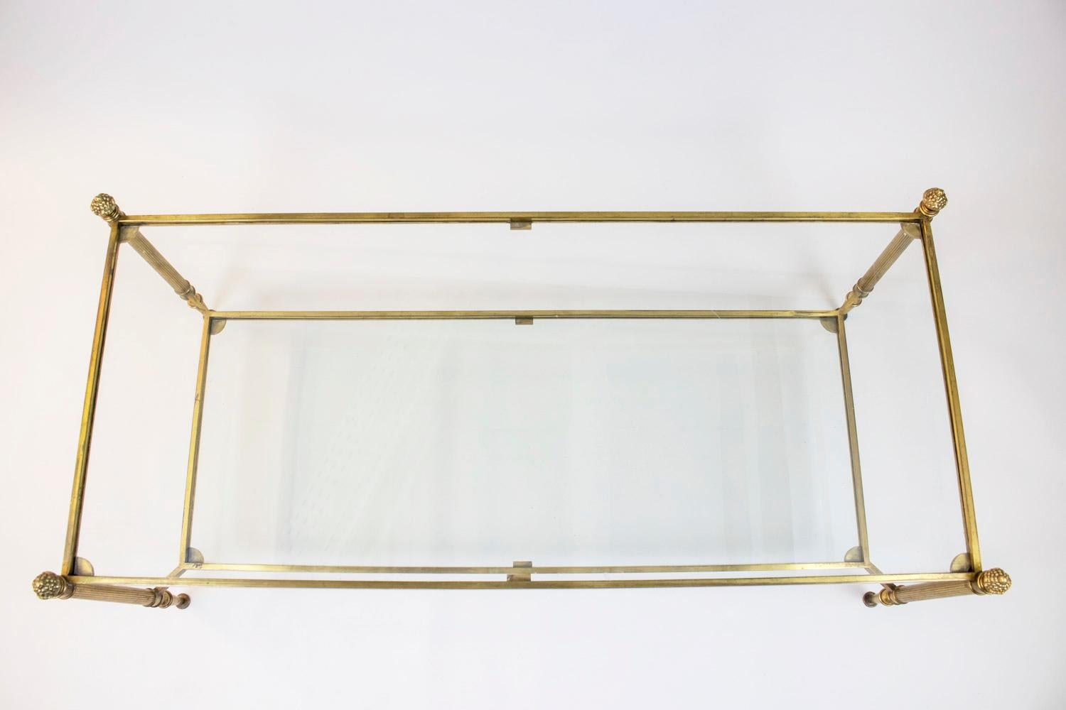Rectangular gilt brass coffee table with standing on four tapered legs with fluted uprights topped by pinecones.
The stretcher in rectangular glass tray framed with gilt brass, such as the upper tray.
Work in the Maison Jansen style, realized in