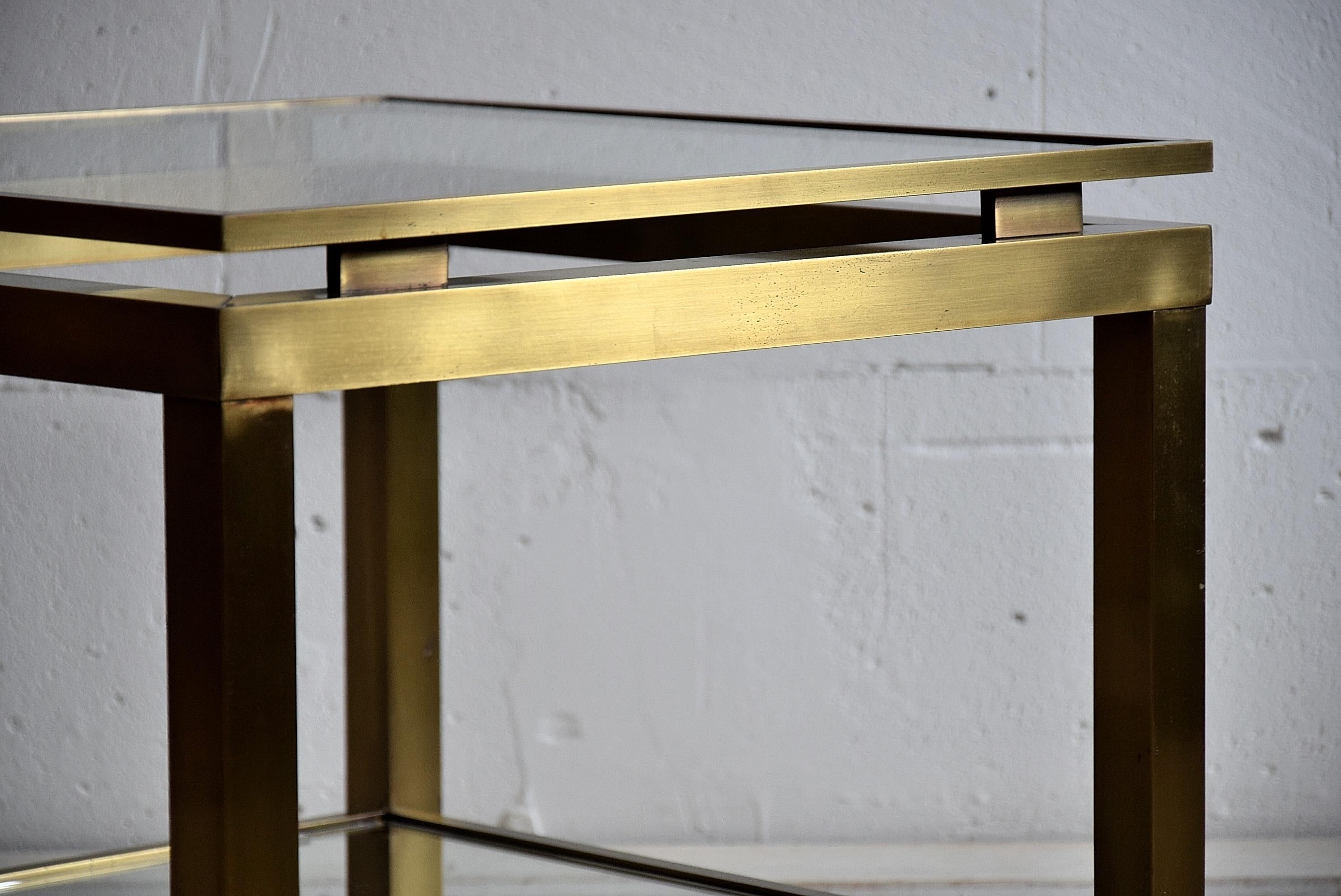 Brass side table by Maison Jansen. Stylish Mid-Century Modern two-tier coffee table by Maison Jansen.
This sophisticated piece is in excellent condition.

Measurements: D 50.5 x W 50.5 x H 46 cm.
The table will be shipped overseas in a custom