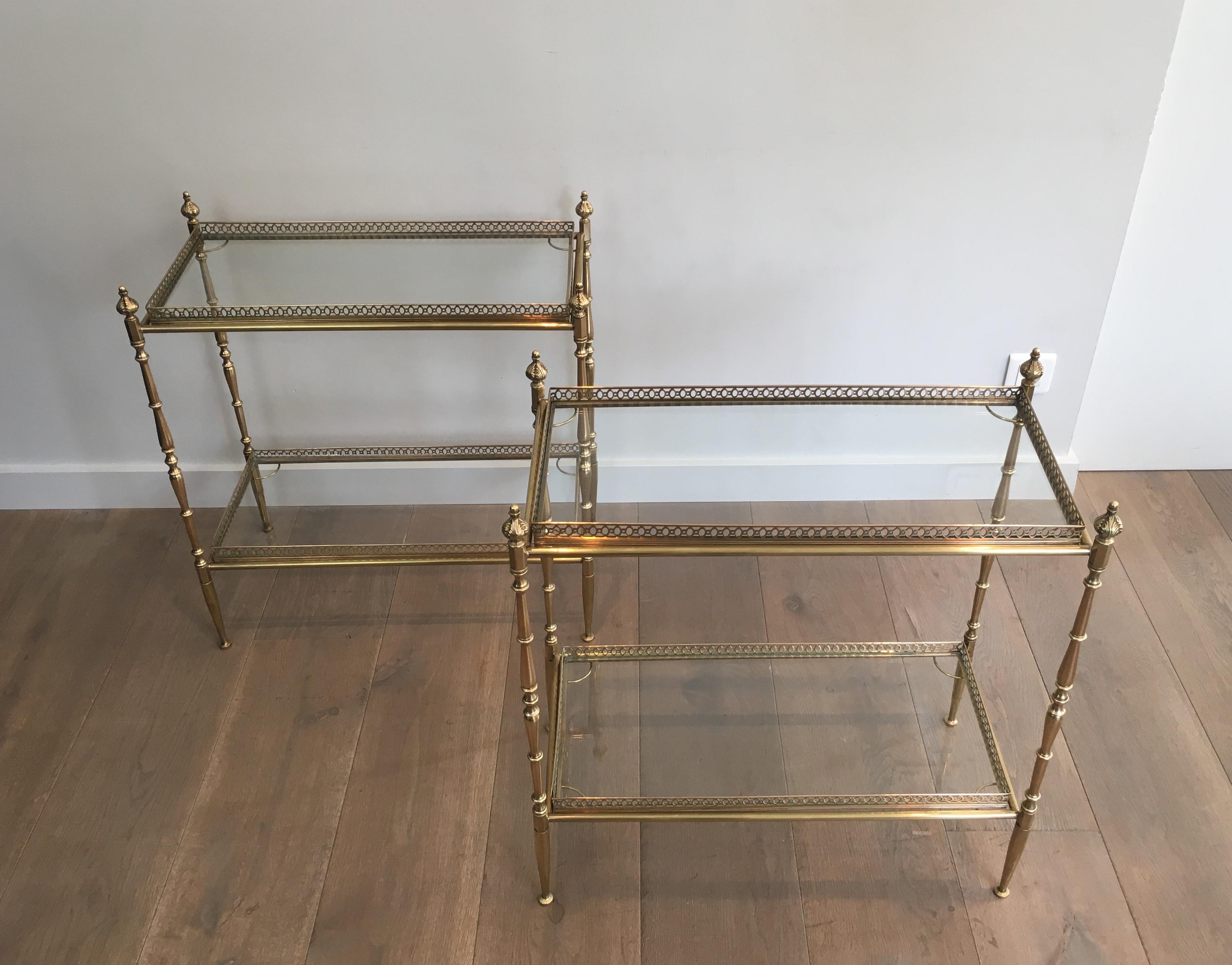 This large pair of neoclassical side tables is all made of brass with clear glass shelves. The glass shelves of these end tables are surrounded with fine brass galleries on bottom and top trays. This is a beautiful fine work by famous French