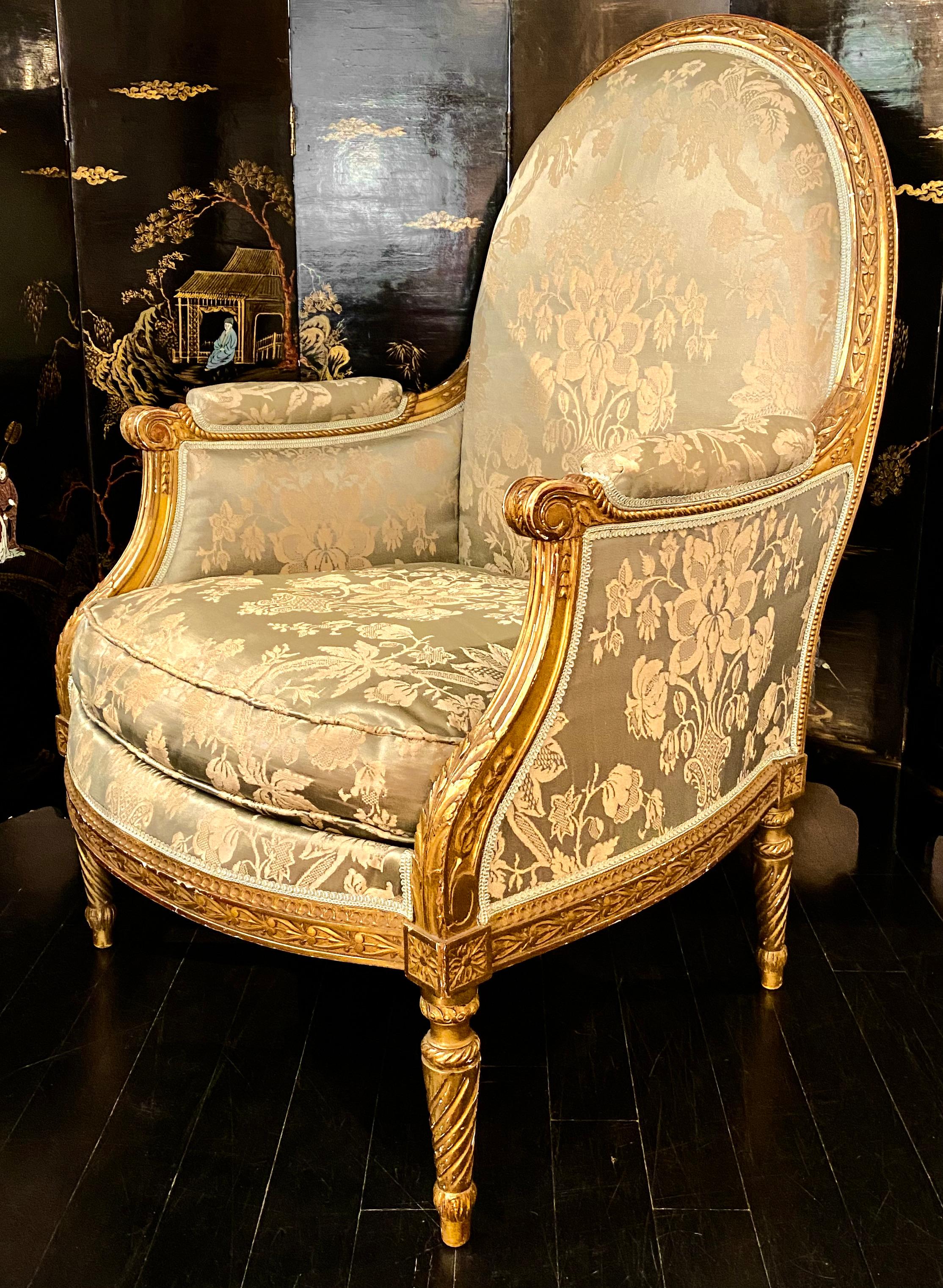 Maison Jansen Louis XVI style giltwood bergère armchair upholstered in pale green silk damask. 
The 