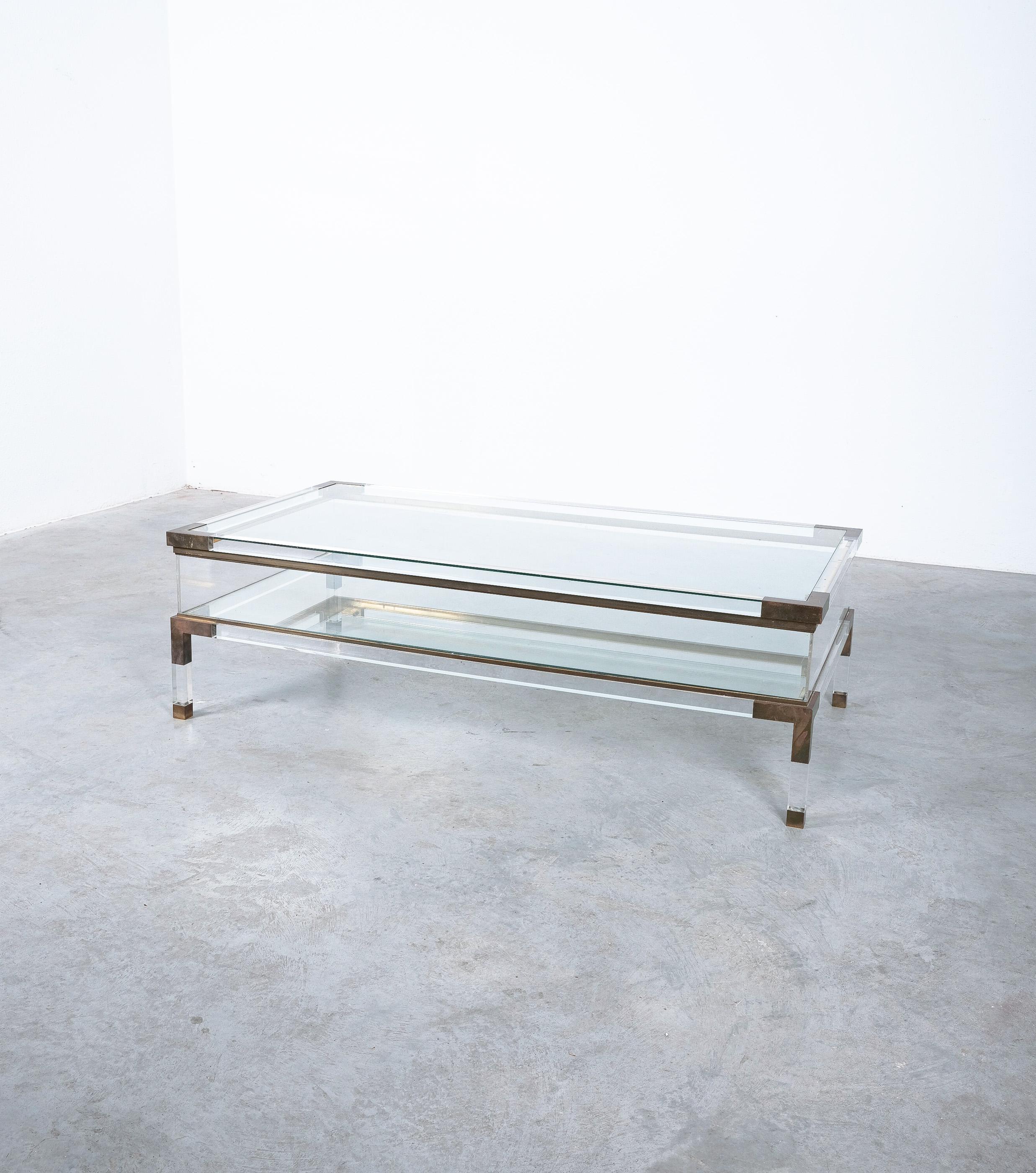 Large vitrine coffee table by Maison Jansen, France mid-century.

Beautiful coffee table by Maison Jansen, 1970, France, featuring polished Lucite elements with brass joints and two glass tops. The lucite and brass framed glass top can slide open