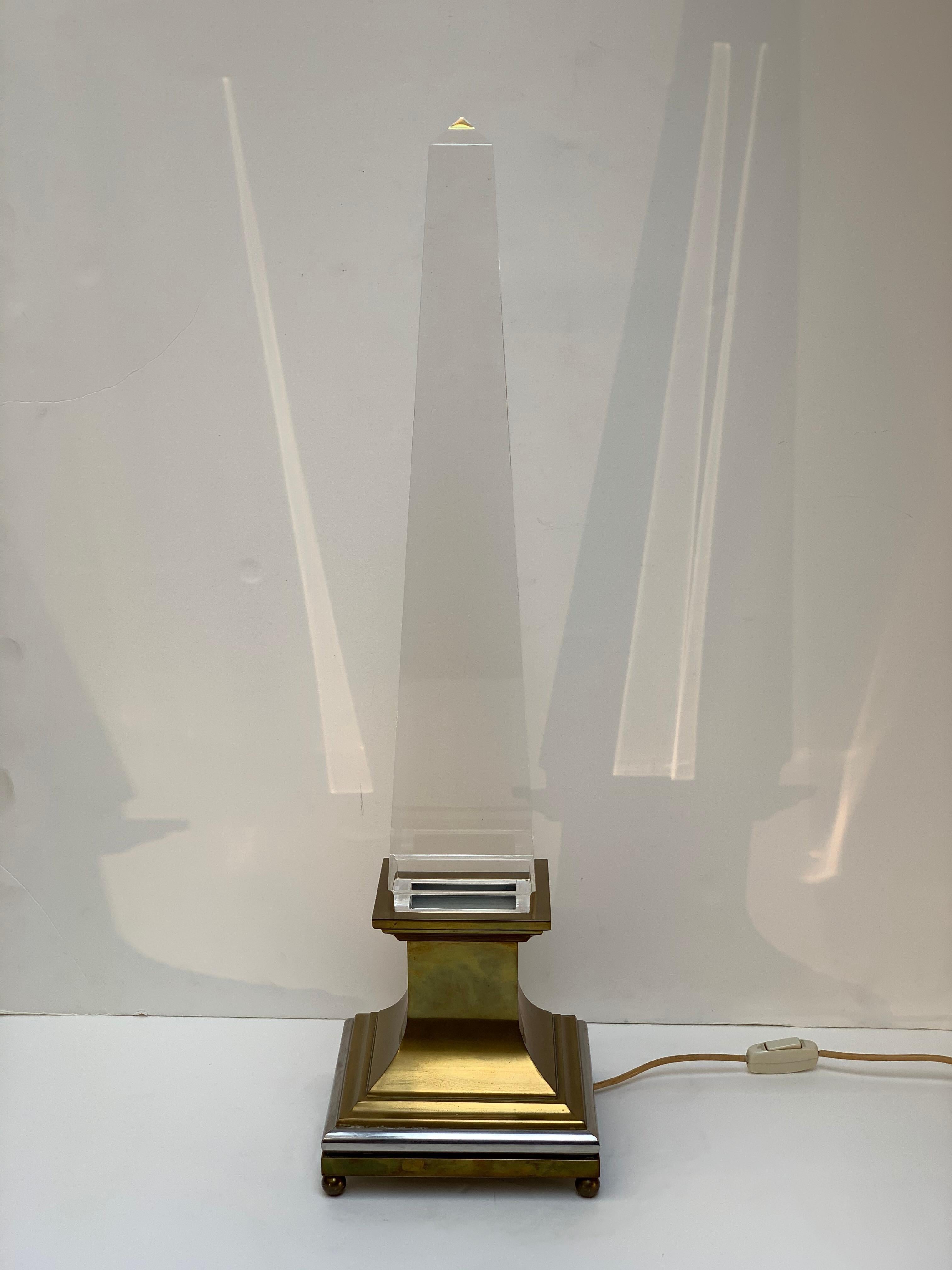 Lamp designed by Italian Architect Sandro Petti for Maison Jansen Paris France with brass base with silver details and large plexiglass obelisk, inside the base two neon lights to illuminate the Lucite obelisk.
Paris France midcentury 1970s.
 