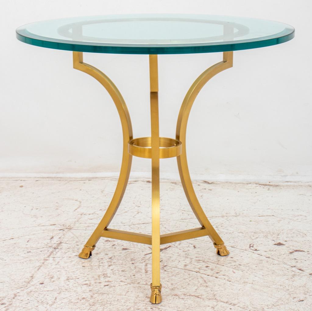 Maison Jansen Manner neoclassical style gilt metal gueridon side table with circular beveled glass top resting on gilt metal supports ending with hoof feet and joined by circular stretcher.

Dimensions: 24