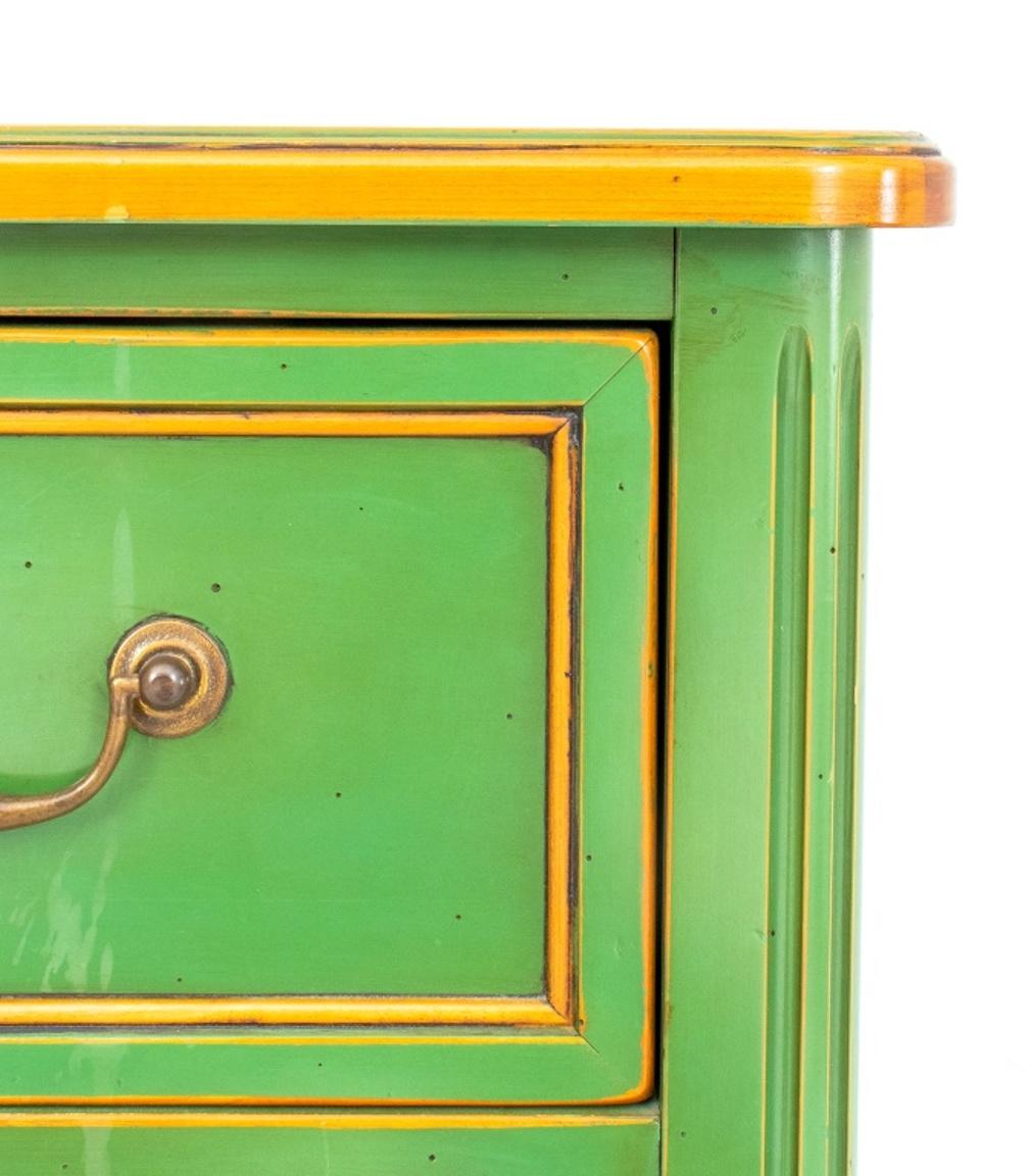 Maison Jansen manner green lacquer and parcel gilded three drawer commode, the rounded rectangular top above paneled drawers with two pulls each and gilt detail.  31