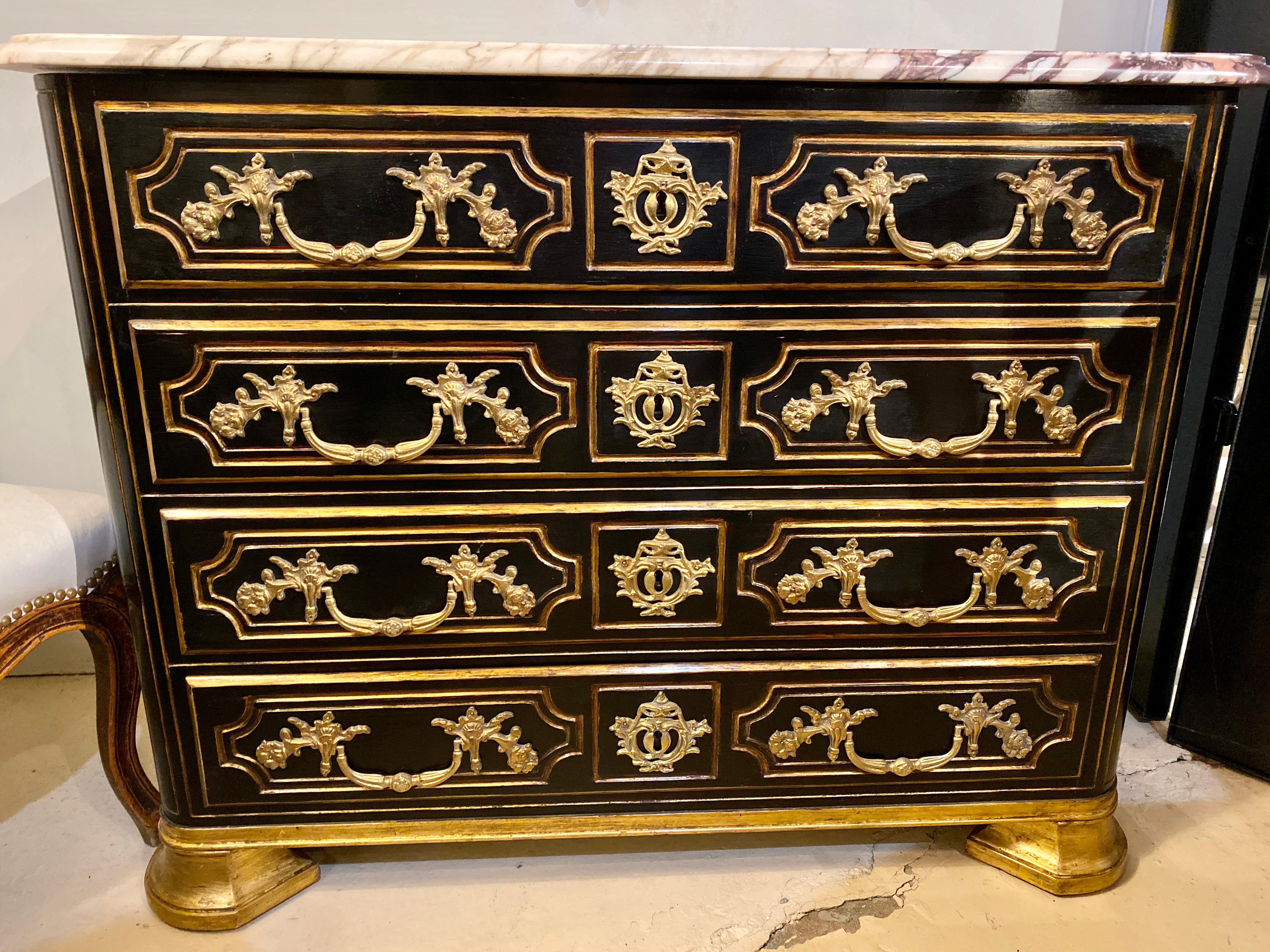 An alluring French Directoire style chest of drawers, circa 1930, a beveled white and rouge veined marble top a conforming ebonized case enclosed with four drawers, each decorated with gilt-banding and ornate bronze pulls, all oak interiors, raised