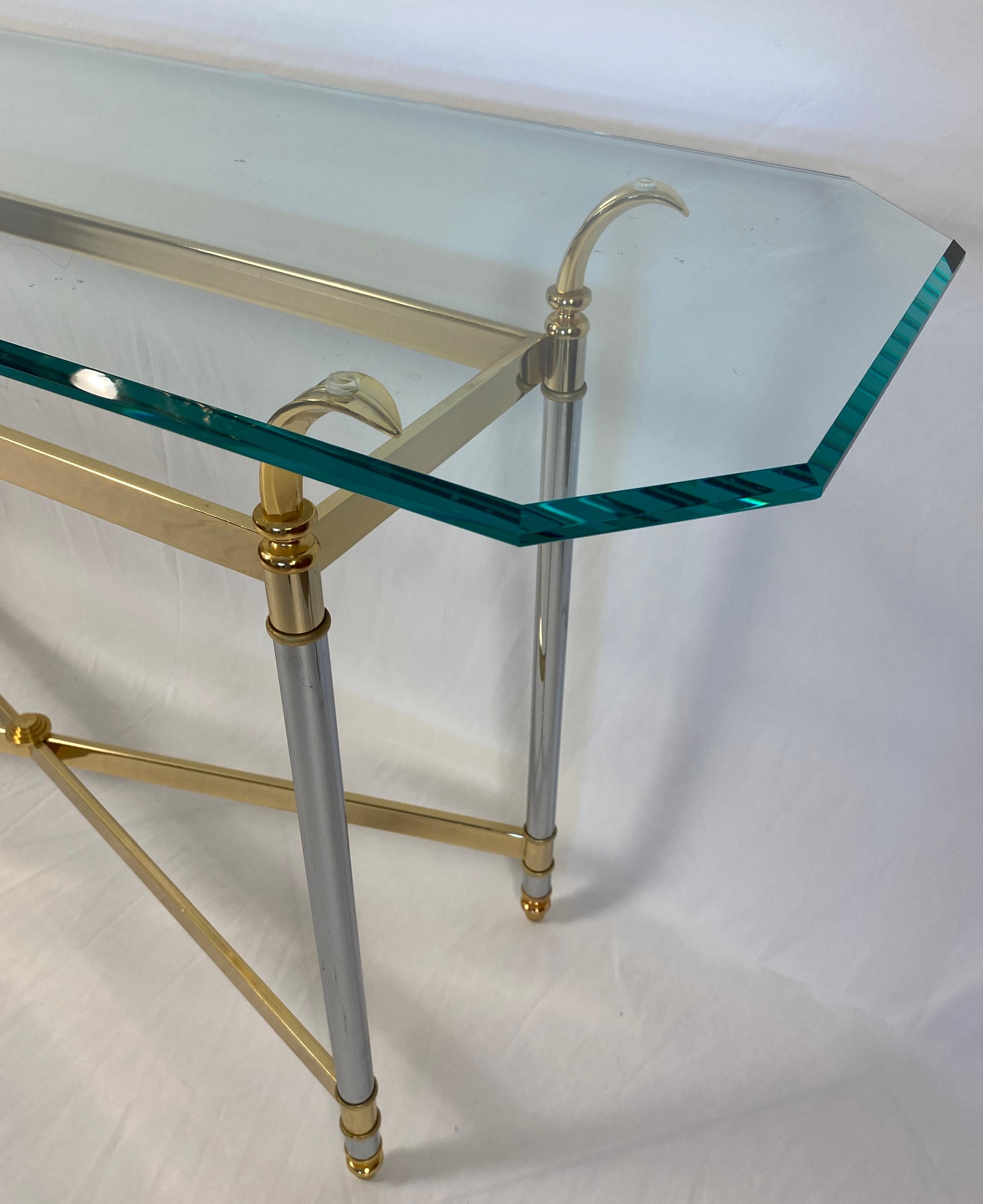 Elegant and stylish vintage Maison Jansen brass and glass console table or sofa table that measures 53