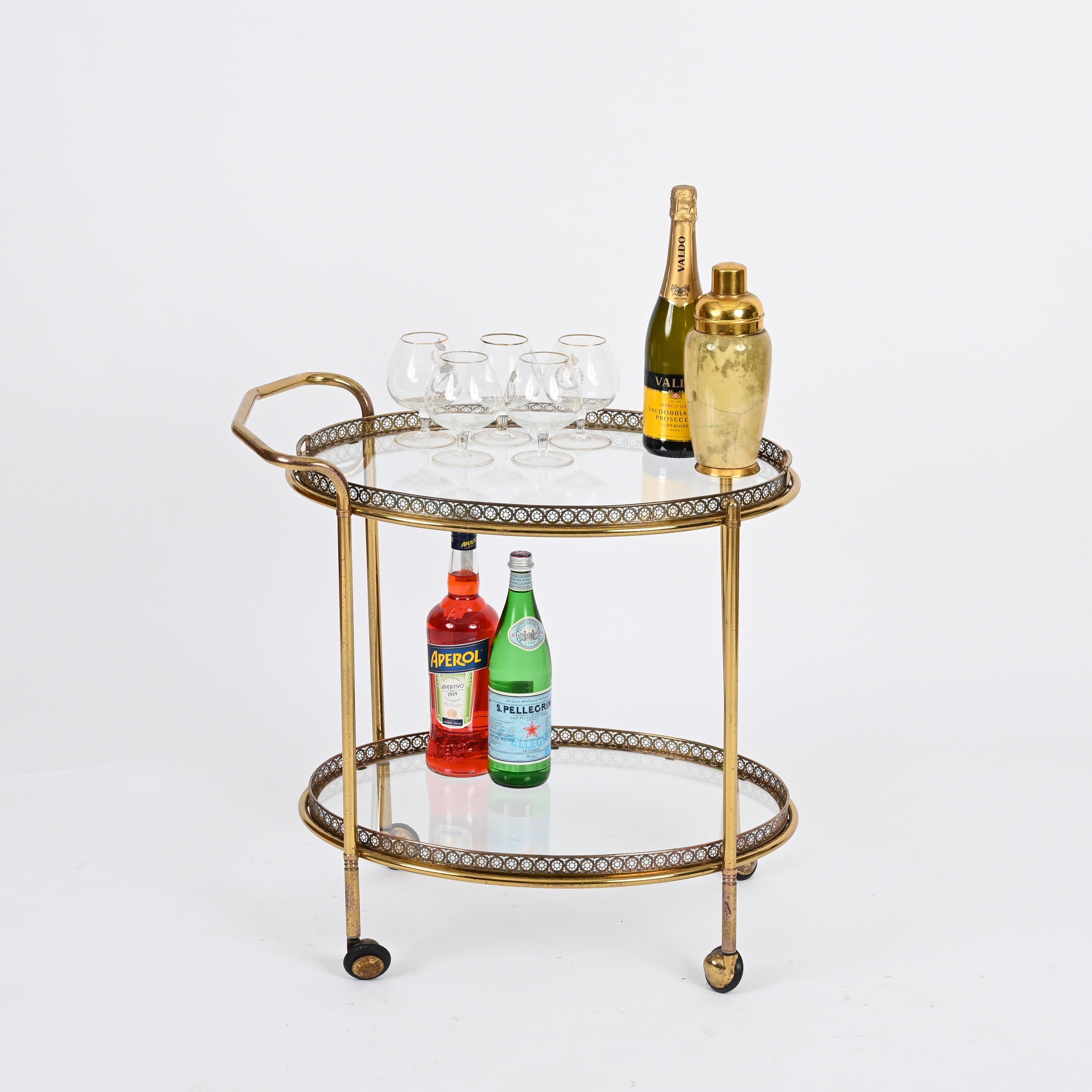 Magnificent midcentury brass serving bar cart with removable top tray. This elegant oval shaped serving trolley was produced by Maison Jansen in France during 1970s.

The structure of this unique piece is made in gild brass, the trays are enriched