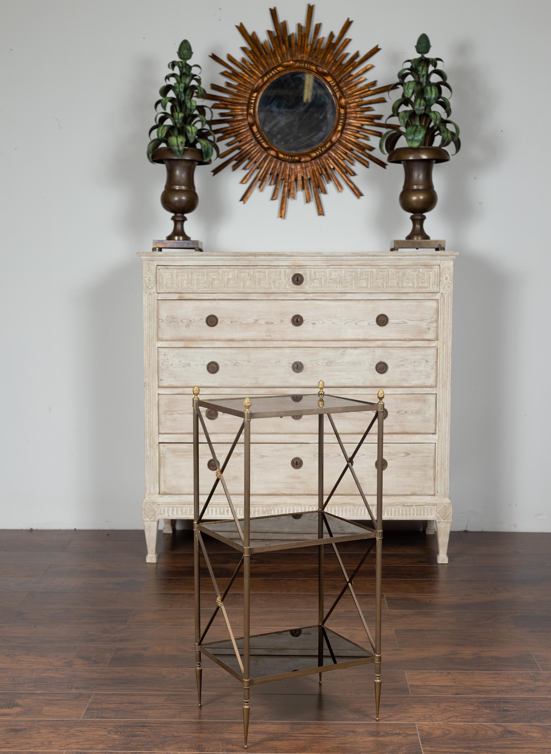 A French vintage Maison Jansen patinated brass three-tiered shelf from the mid-20th century, with black mirror. Born in France during the midcentury period, this stylish tiered étagère features a patinated brass structure topped with delicate