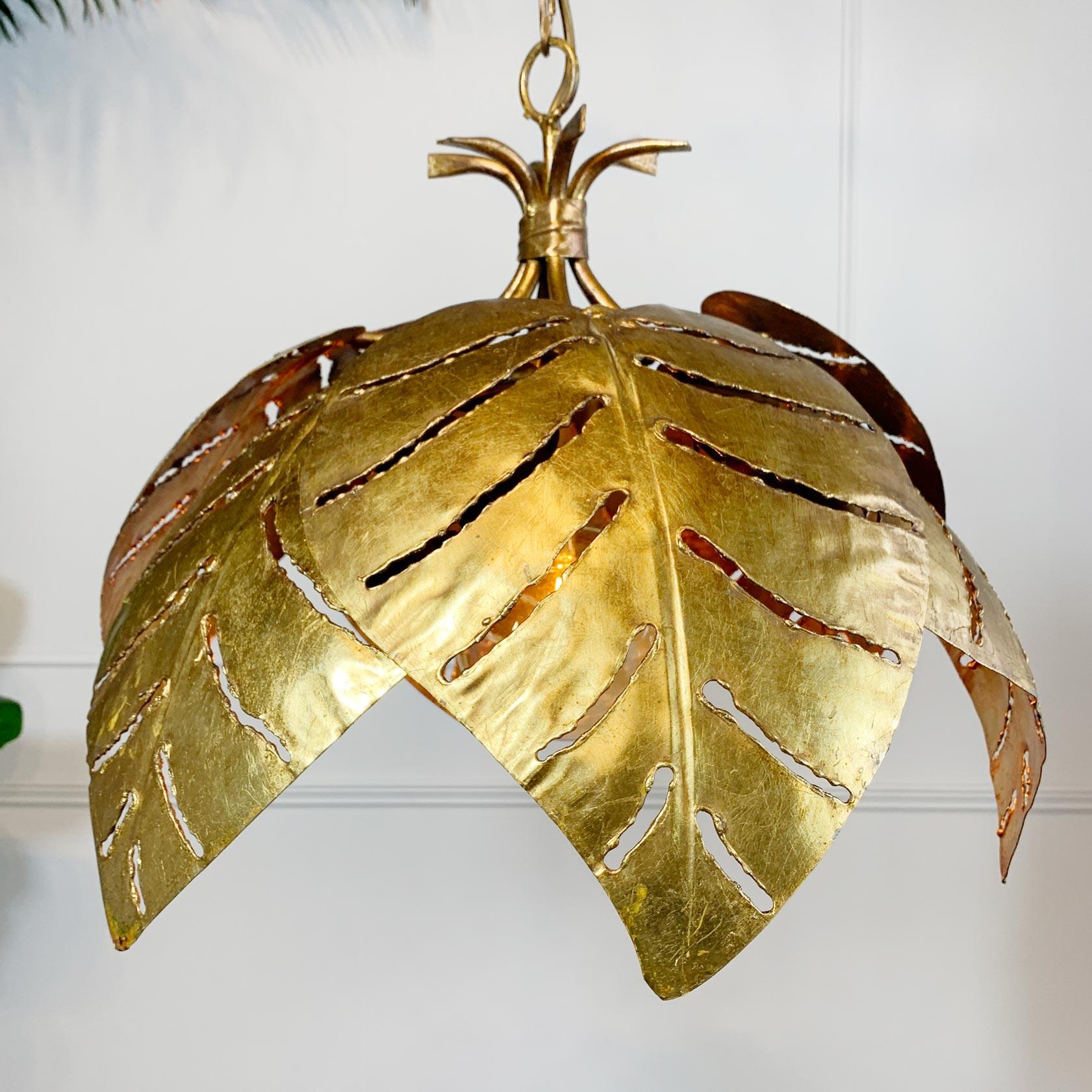 An incredibly rare Maison Jansen gilt metal chandelier, the six large Monstera leaves overlapping to create the canopy of the light, the stems tied together with a leaf detail and adjoined to create the roof of the chandelier. This is of a wonderful