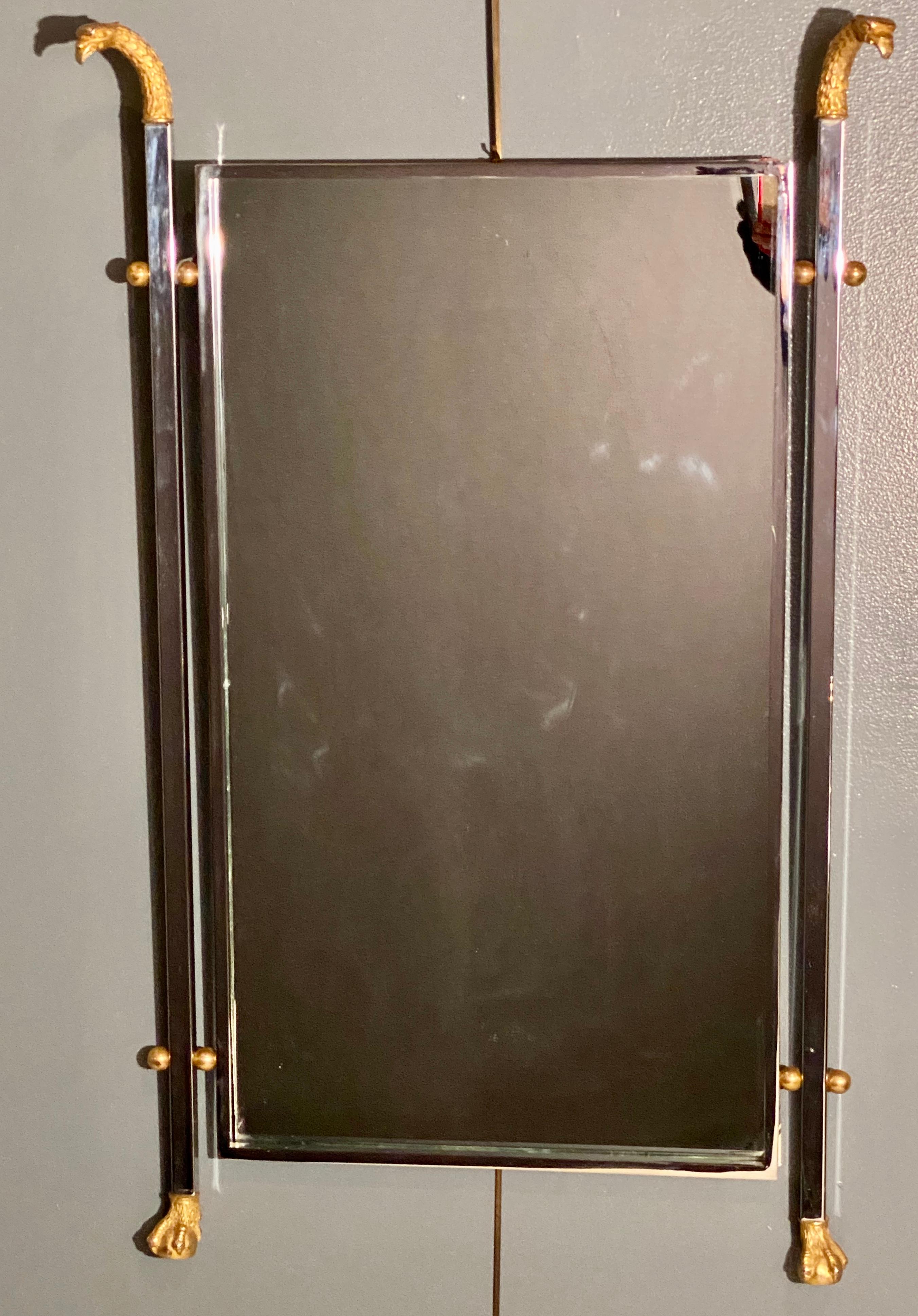 A Maison Jansen neoclassical eagle motif mirror in a steel and bronze finish. A stunning example of this highly sought after designers work is indicative to why so many designers are using his work in so many settings. The bronze Eagles heads flow