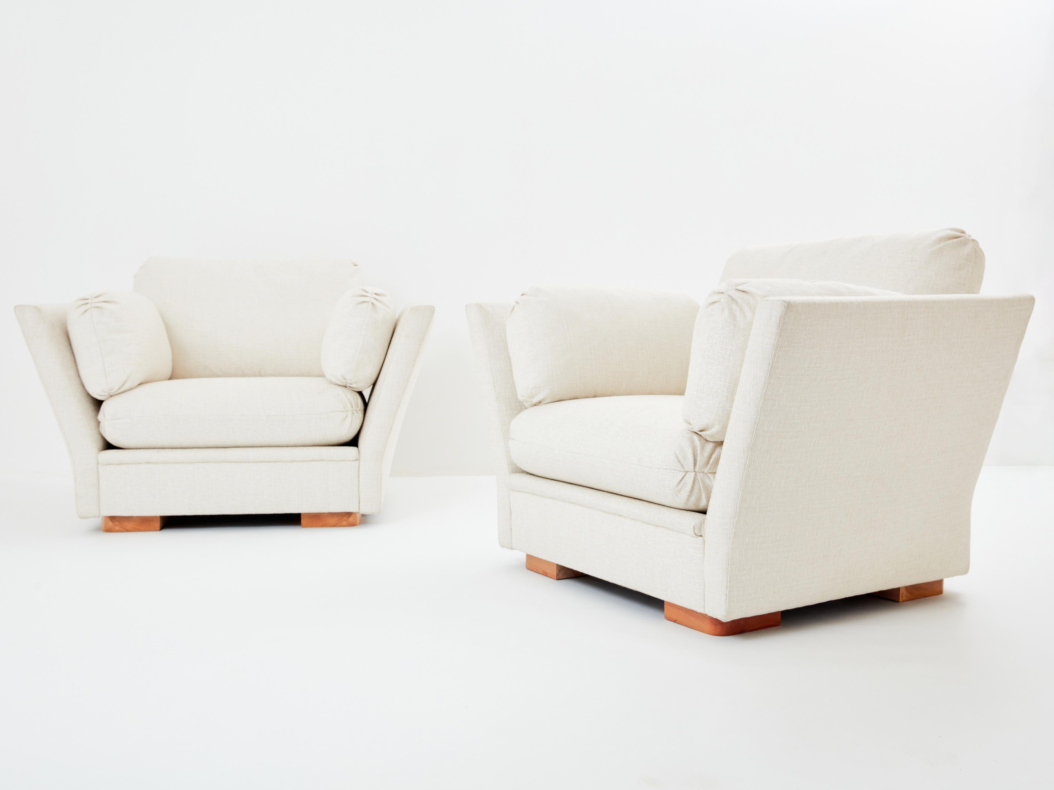 Neu gepolstert in einem beruhigenden, strukturierten, cremefarbenen Stoff von Pierre Frey, ist dieses schöne Sesselpaar ein perfektes Beispiel für den Neoklassizismus von Maison Jansen aus den 1960er und 1970er Jahren. Mit ihren großen Armlehnen,