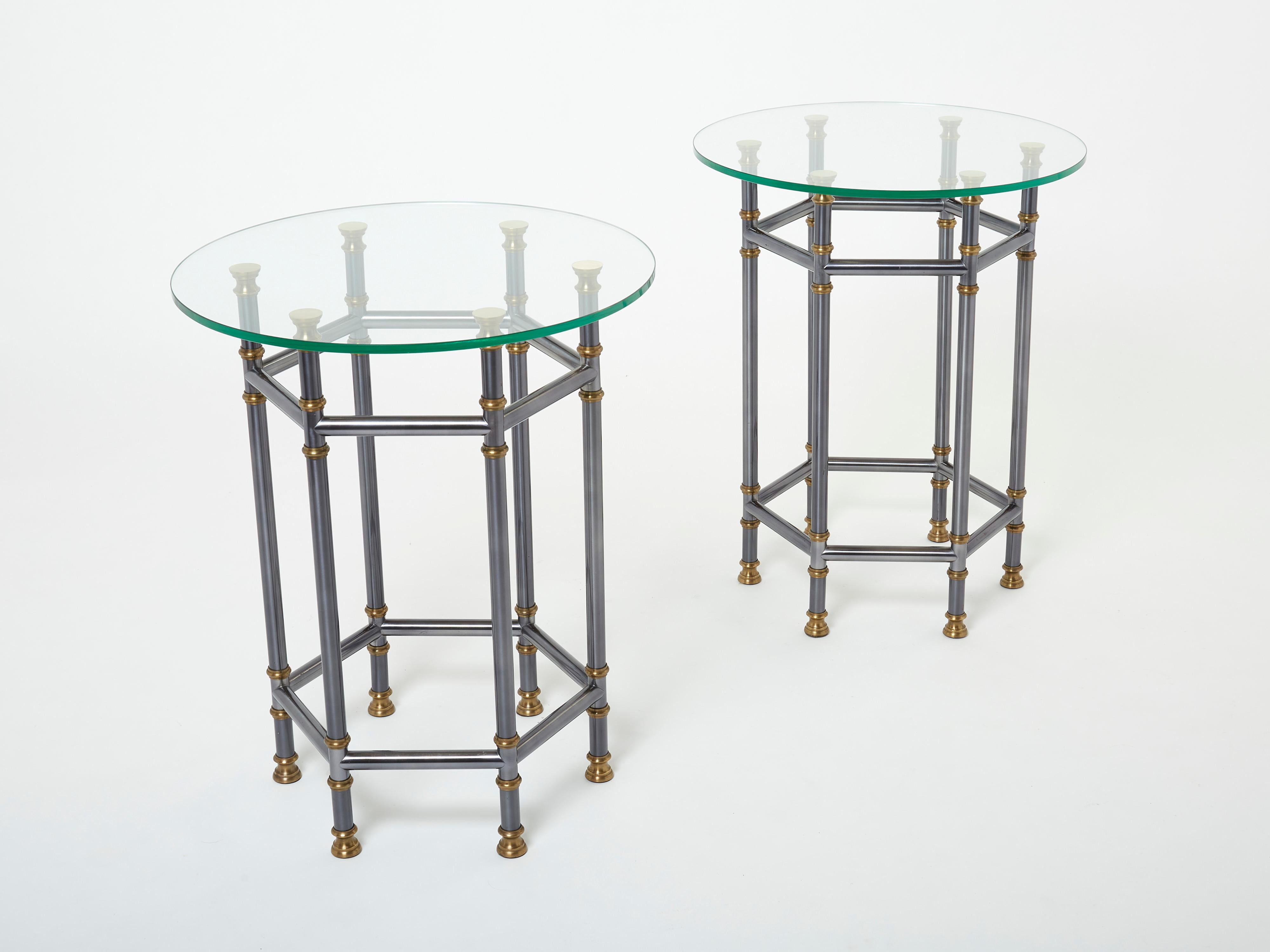 These beautiful gueridon side tables by Maison Jansen were created with typical French neoclassical style gunmetal and solid brass mix in the early 1970s. The thick round glass top is finishing the pair smoothly. Their sophisticated design is