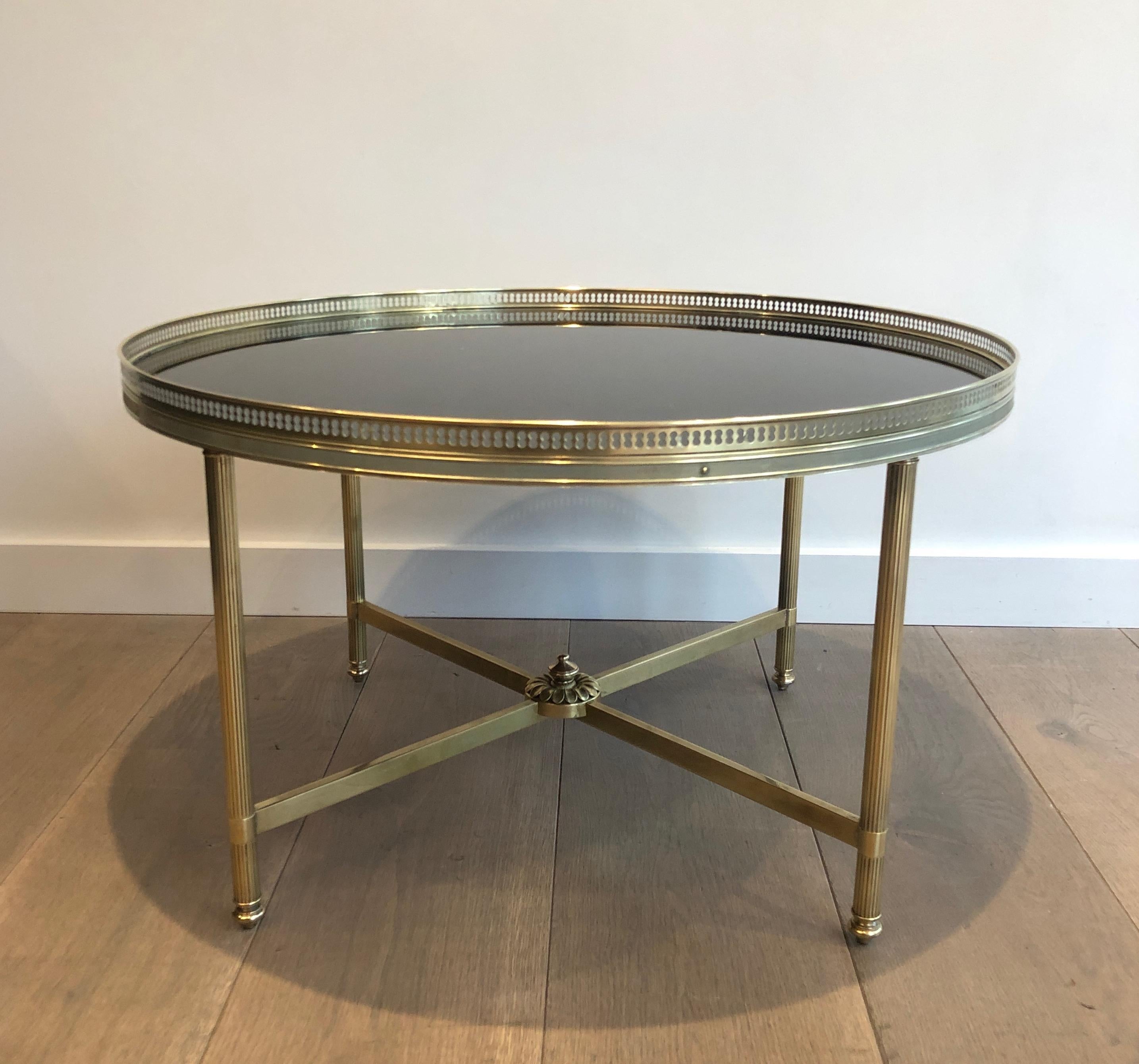 Cette très belle et élégante table basse de style néoclassique est en laiton avec un plateau en verre laqué noir. Il s'agit d'une œuvre française de la célèbre Maison Jansen. Circa 1940.