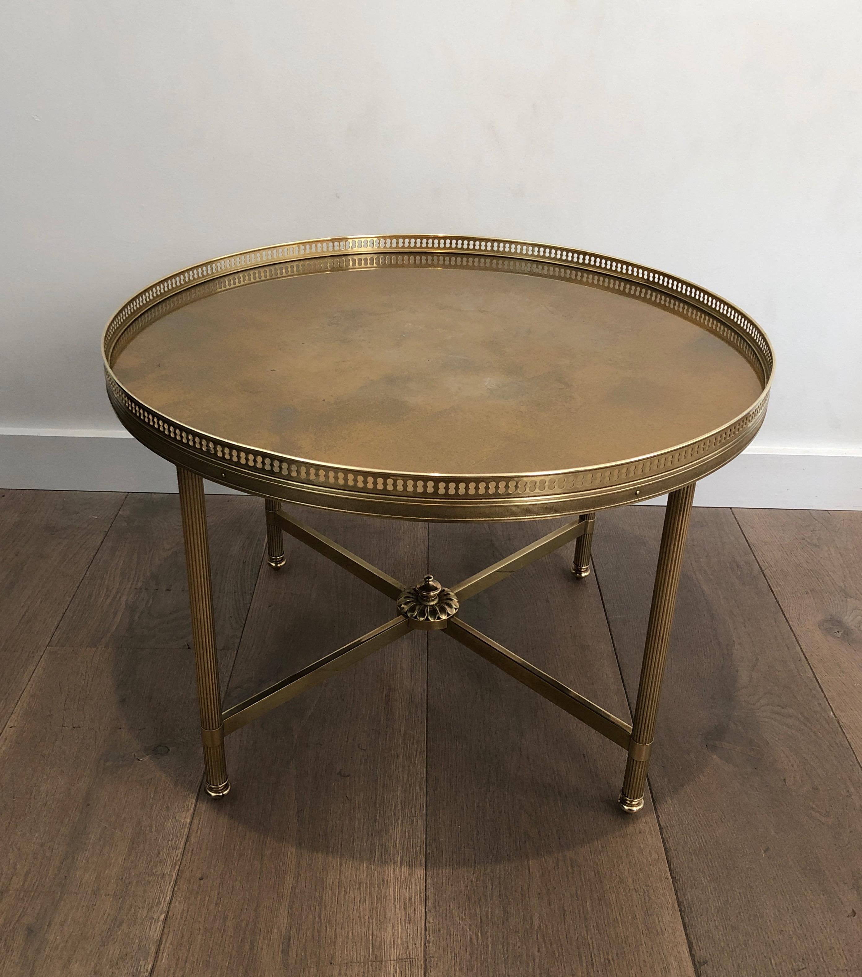 This neoclassical style small round coffee table is made of brass with gold shelf on top. This is a work by famous French designer Maison Jansen, circa 1940.