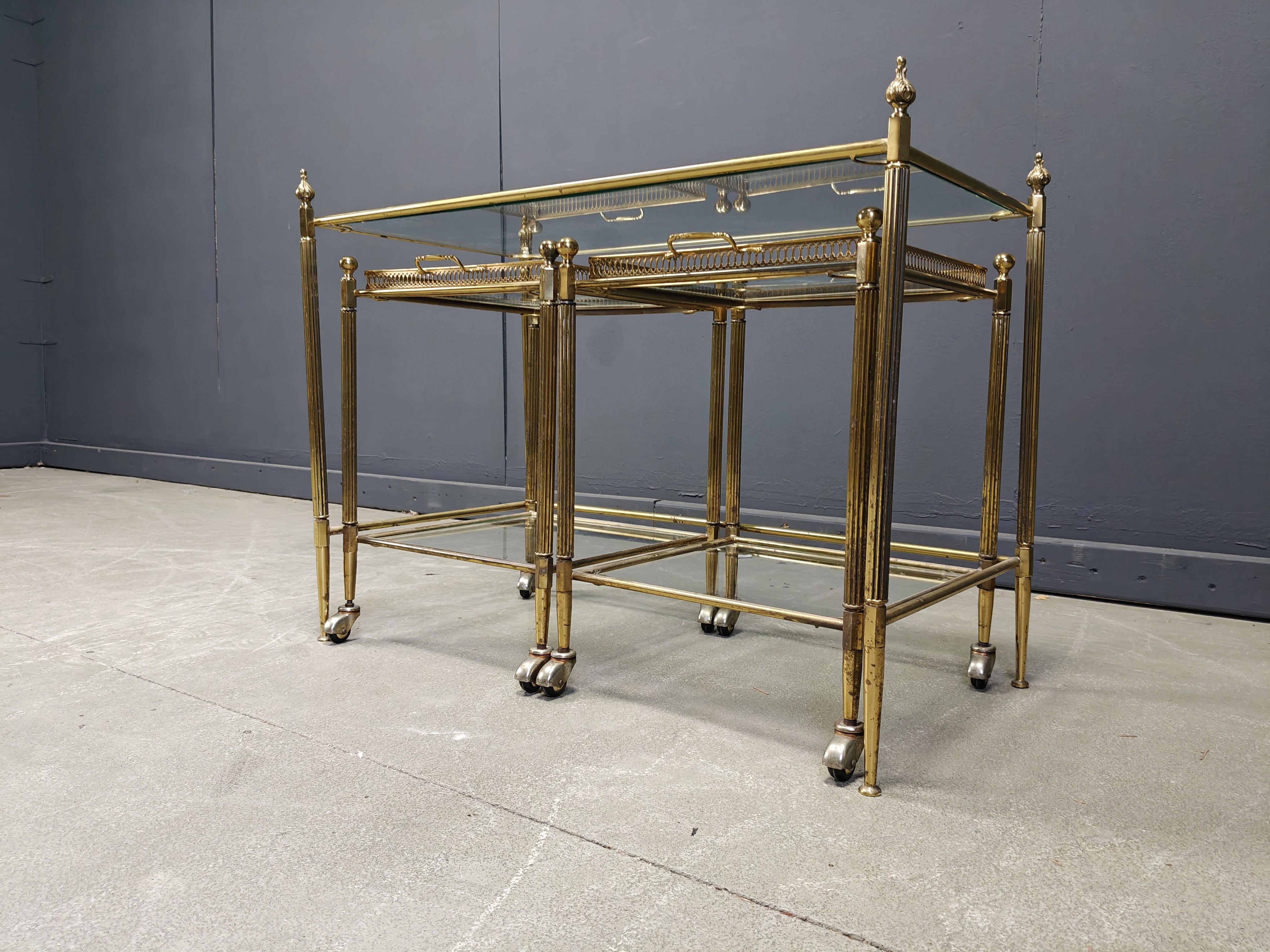 Table d'appoint en métal doré du milieu du siècle par la Maison Jansen avec une paire de tables d'appoint sur roulettes avec plateaux de service amovibles. 

Montures en métal doré très joliment patinées et couvercles en verre transparent.

Années