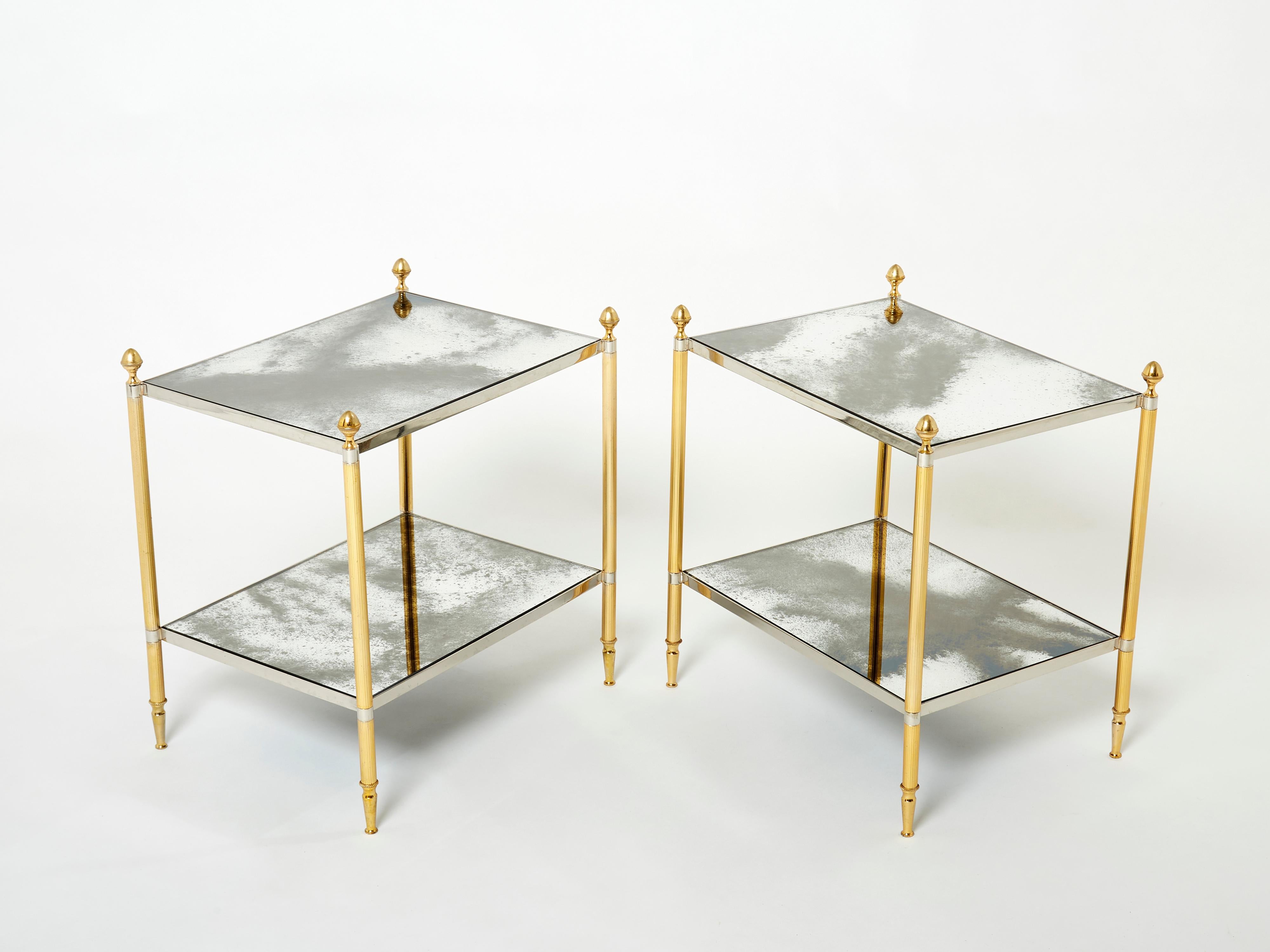 This pair of two-tier end tables by French design house Maison Jansen was created with beautiful brass legs, chrome strappings, typical french neoclassical pine cones, and beautiful old patina mirrors in the 1970s. The two-tier mirrors are timeless