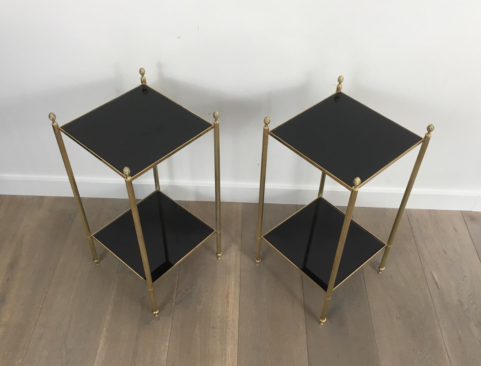 This pair of side tables are made of brass with new black lacquered glass shelves. They have fluted legs with delicate finials. This is a fine work by famous French house Maison Jansen, circa 1940.
 