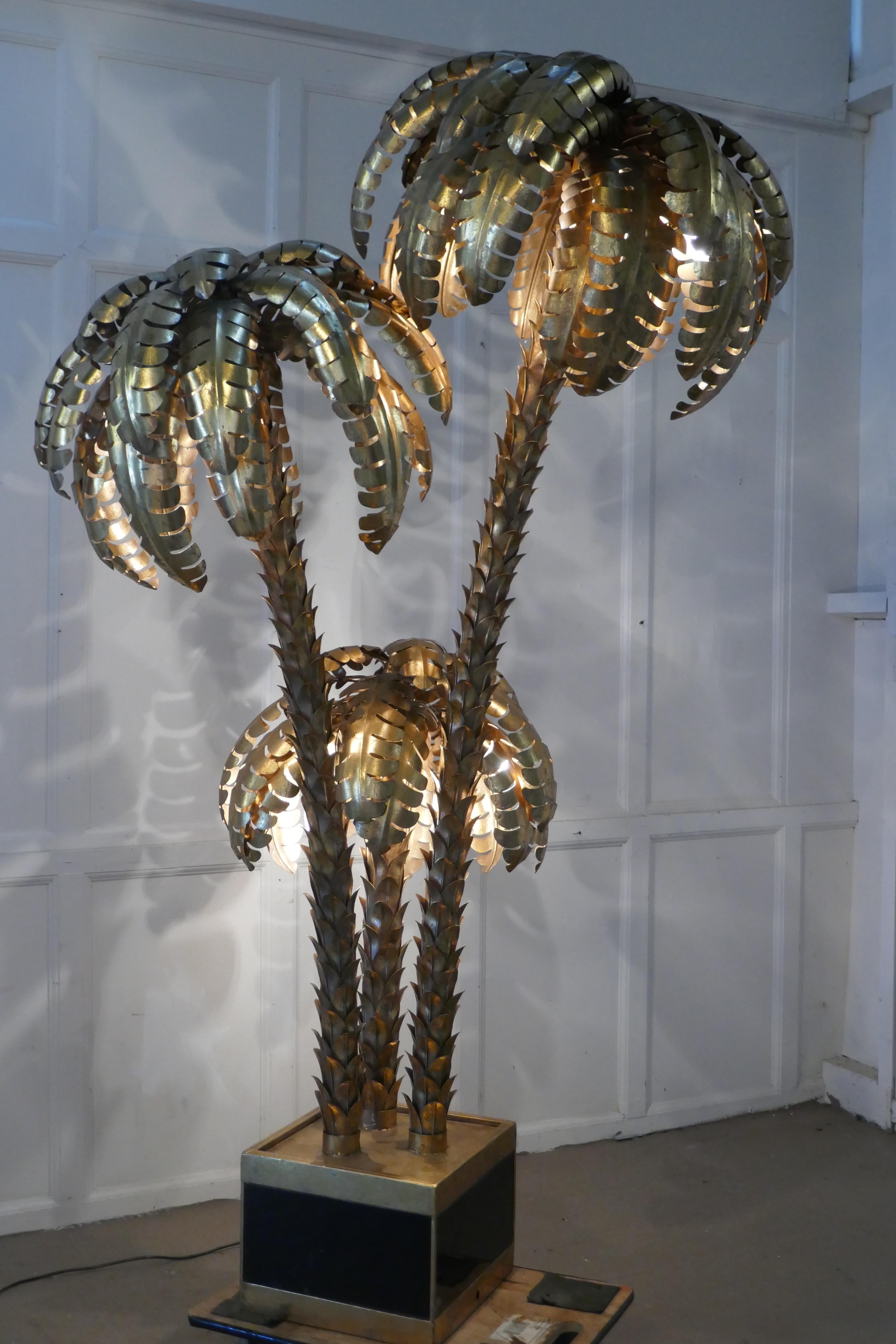 Palm Tree Tole Ware floor lamp, French, 1970-1980

Very rare Triple palm tree floor light, the lamp has 3 spiky trunks with abundant curling brass Palm leaves overhanging eac

The tree is 75” in height, it is about 42” across and heavy
JF90.