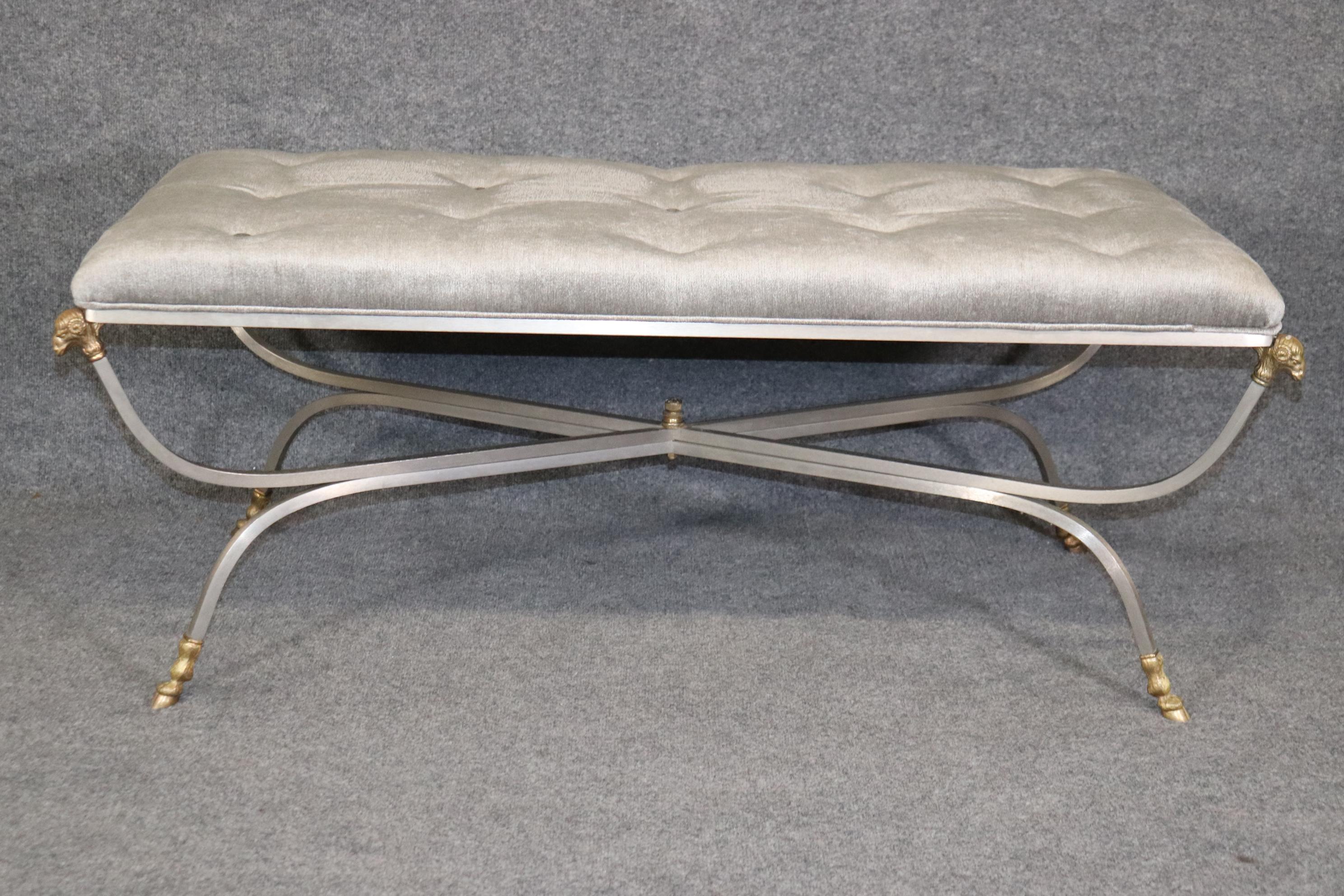 Dimensions- H: 20 1/4in W: 50in D: 26in 
This Maison Jansen Rams Head Brass And Brushed Steel Tufted Bench is made of the highest quality and is equipped with luxurious brass rams heads on each corner of the bench/ottoman. If you look at the photos