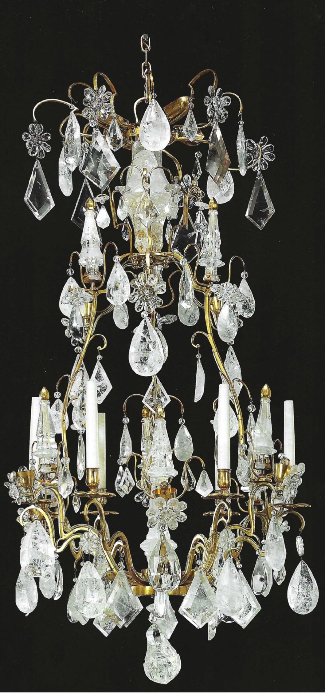 A Maison Jansen French ormolu and rock crystal six-light chandelier (mid-20th century). Of Louis XV style, the open cage centred by an upswept faceted sprig with ormolu finial, the shaped branches with flowerhead shaped drip pans and plain nozzles