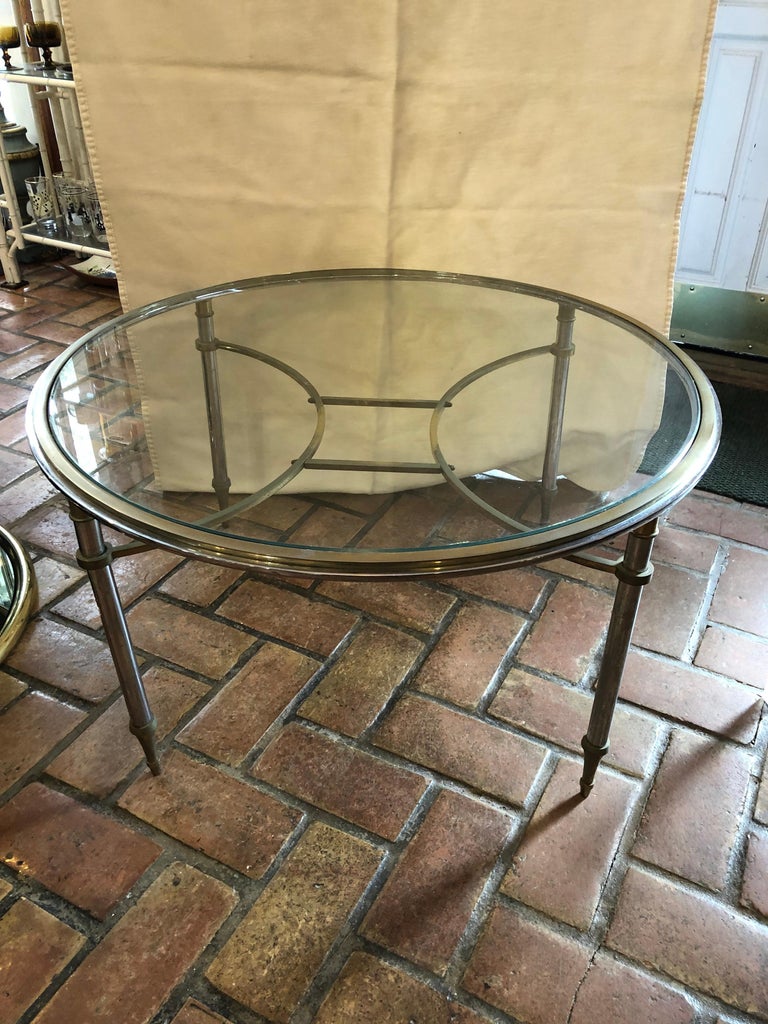 Round brass and steel coffee table attributed to Maison Jansen with removable glass top. Very heavy piece. Solid and well made. Some fading to brass finish. Priced to move fast as we need the floor space.
 