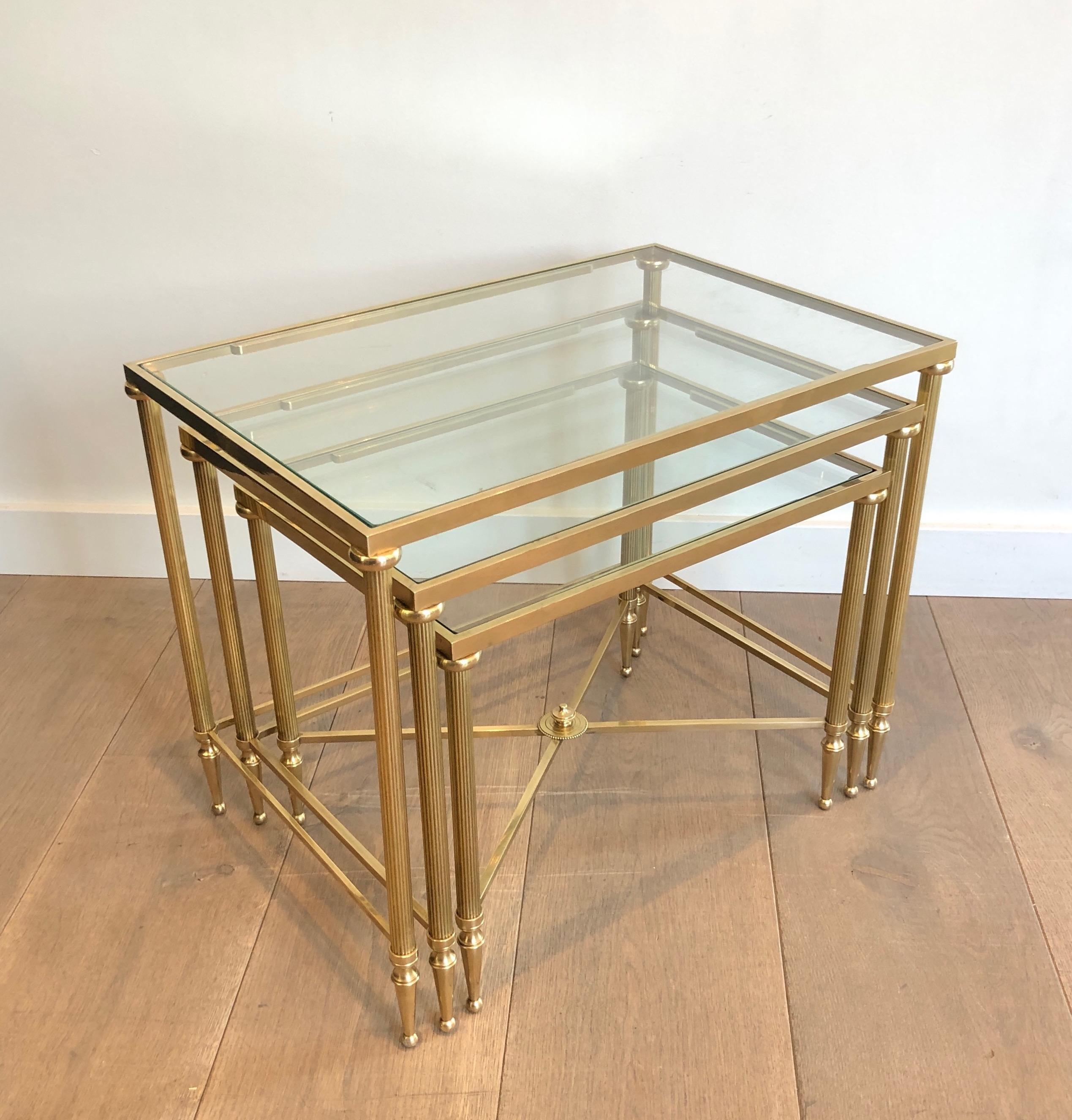 This set of 3 nesting tables is made of brass and glass. This is a work by famous French designer Maison Jansen, circa 1940.