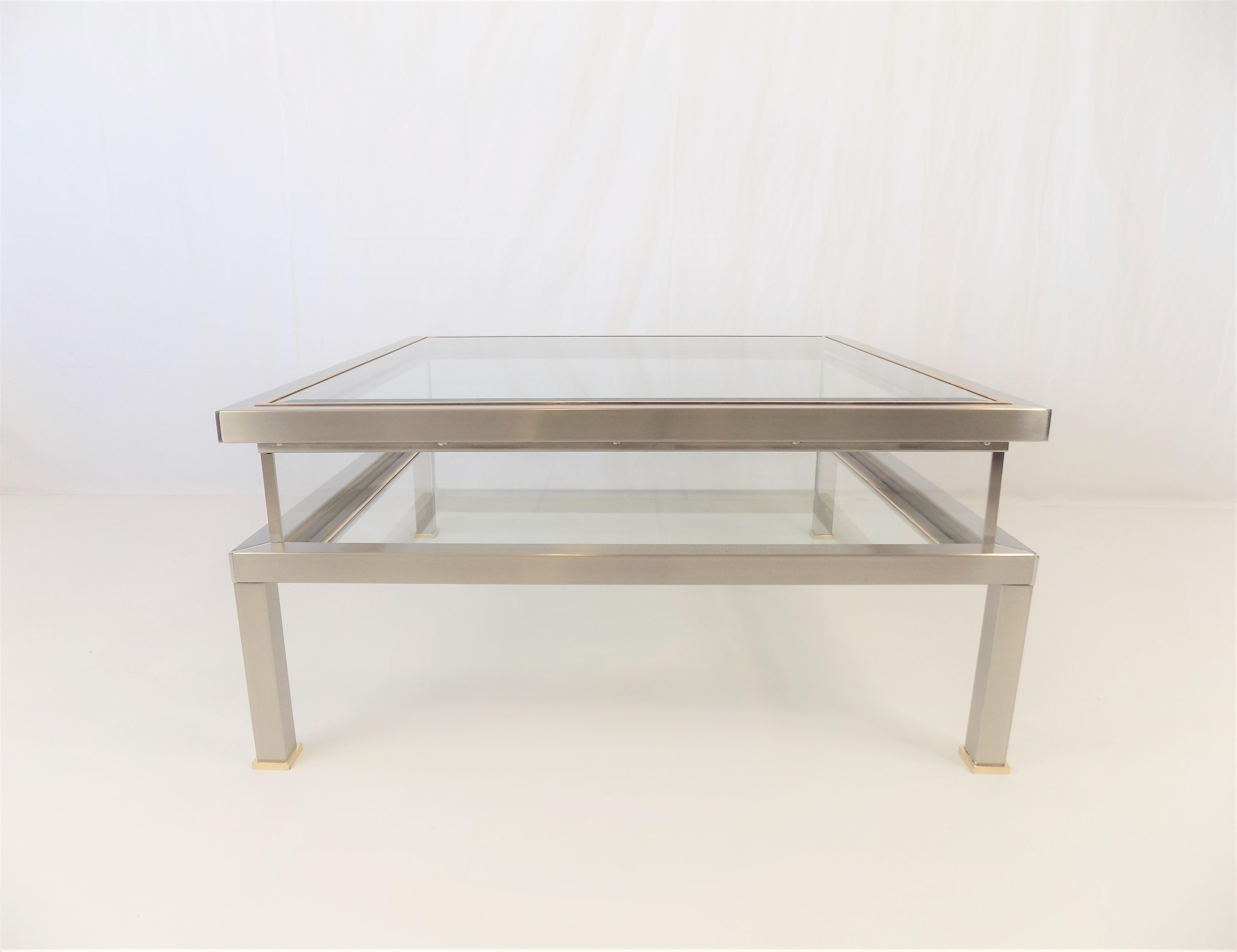 This coffee table has a sliding function on the top table top which turns it into a display table. It offers the possibility to show collectibles, magazines, etc. in the display. The table is made of solid stainless steel, the frames of the two
