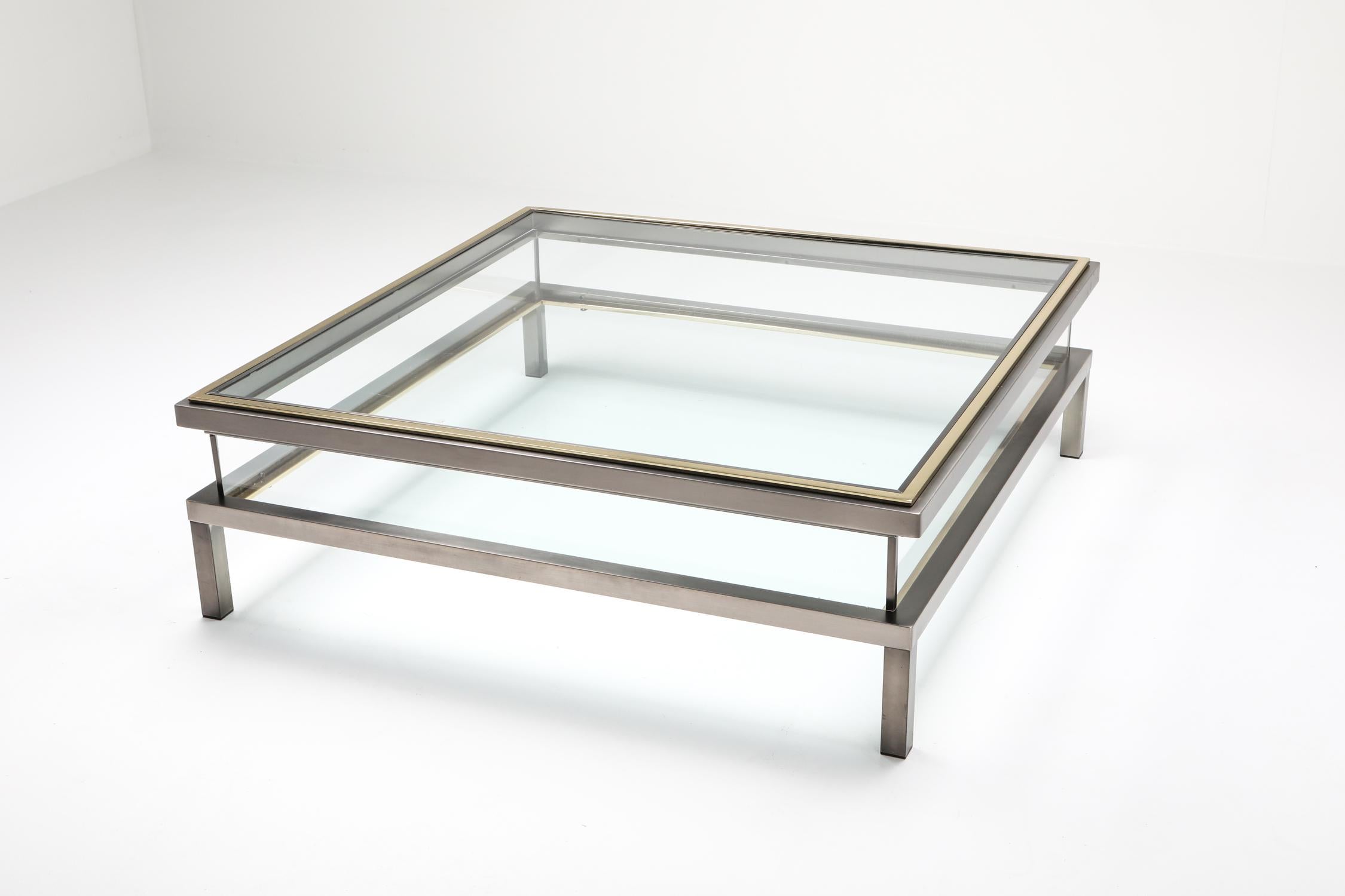Sliding coffee table, Maison Jansen, France, 1970s

The coffee table slides open which allows one to store magazine, glass work or anything you'd like in the middle compartment.
Chromed steel frame with a brass plated top edge.
Would fit well in