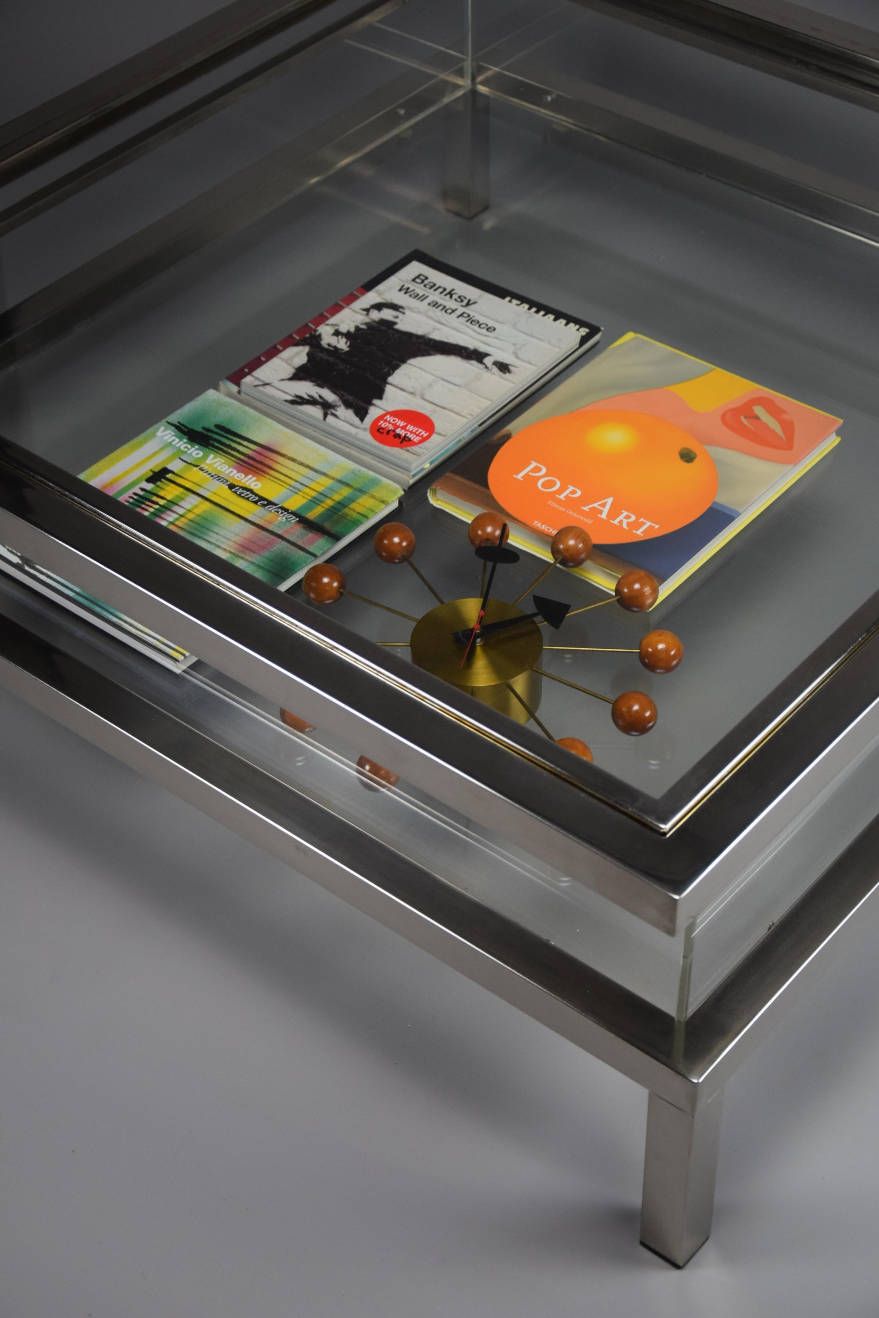La caratteristica principale di questo tavolo è il suo piano scorrevole che, senza sforzo, rivela uno spazioso vano sottostante. Questa funzione unica ti permette di esporre con stile libri, opere d'arte o altri oggetti cari, trasformando il tuo