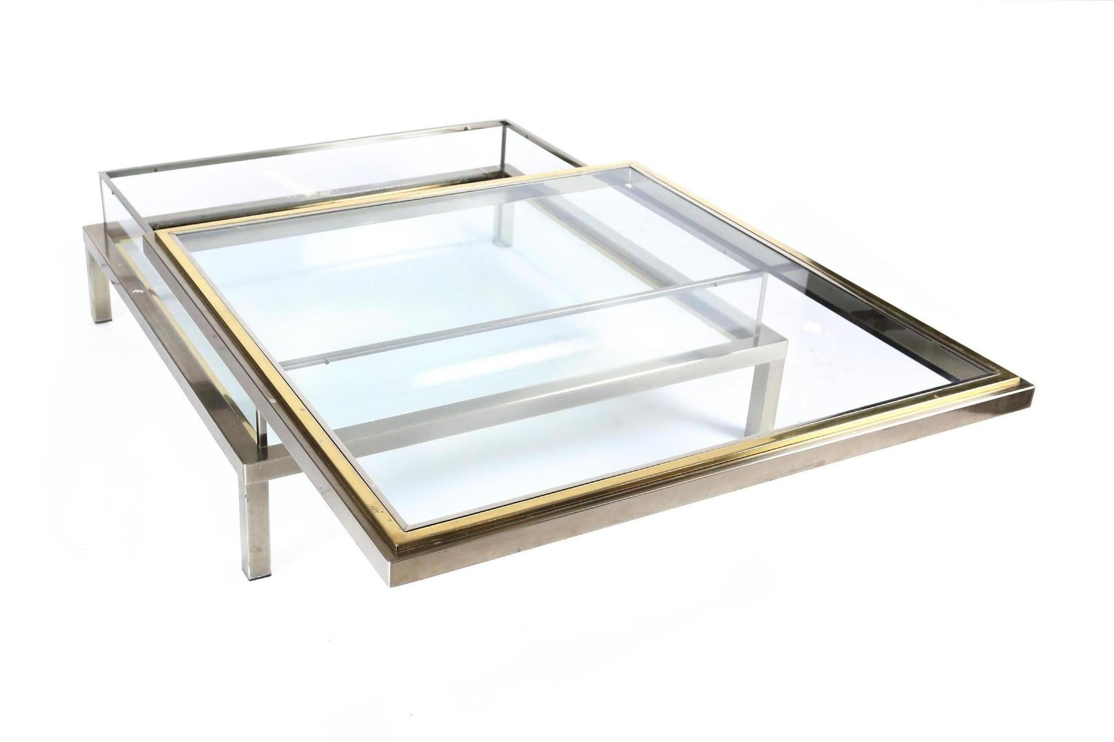 1970s coffee table in good condition.
Satined chrome and brass with glass tops 
The top can slide open to reveal the inside compartment that can be used as a vitrine for books and magazine.