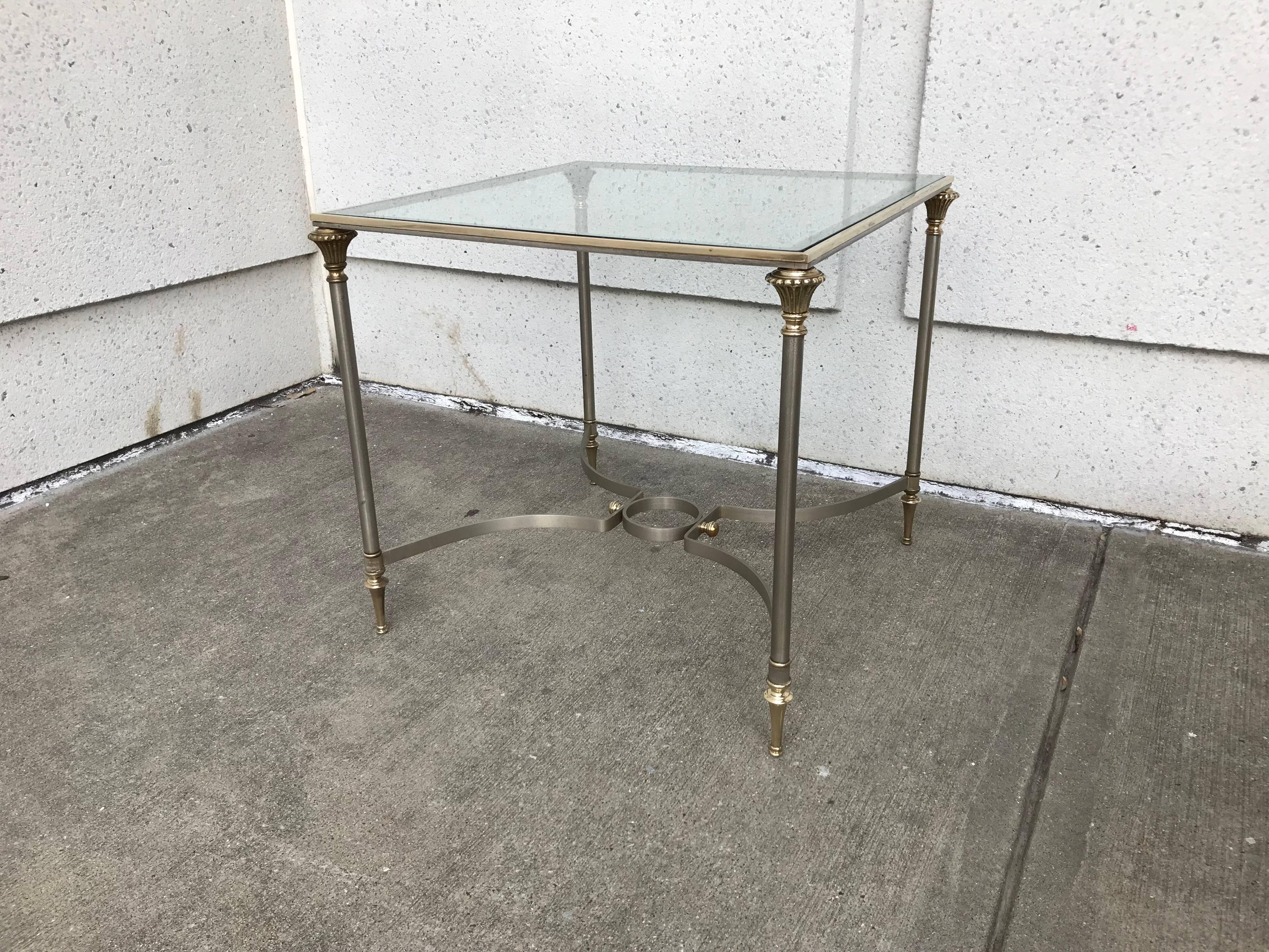A handsome Italian made Maison Jansen style brushed steel and bronze side table in the neoclassical style. Beautifully crafted with steel legs over bronze trumpet feet topped by fluted capitals. The X-stretchers joined in the center by a circle,