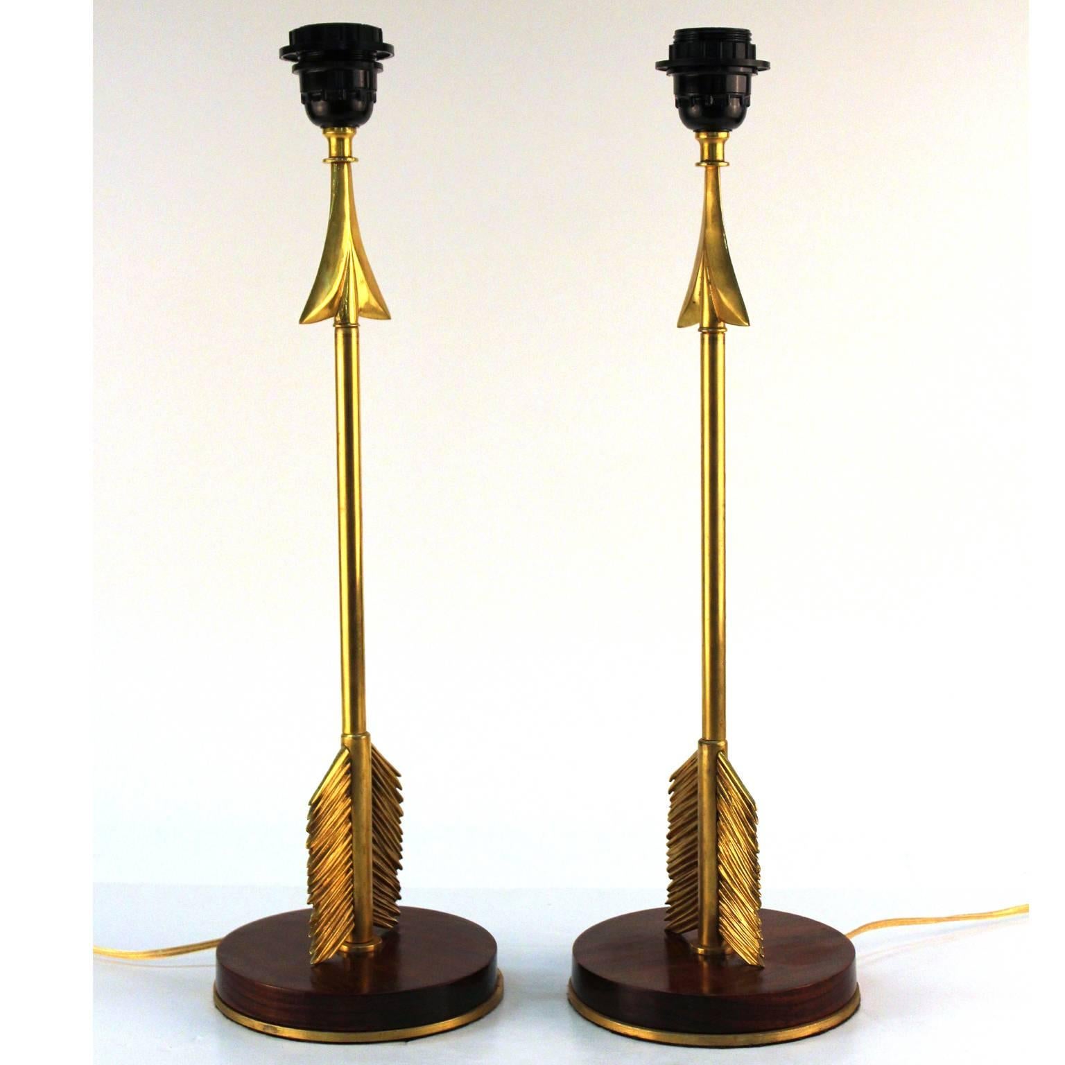 A pair of 1940s French Maison Jansen style arrow table lamps made of gilded bronze on a mahogany wood base. Good condition with minor scratches.