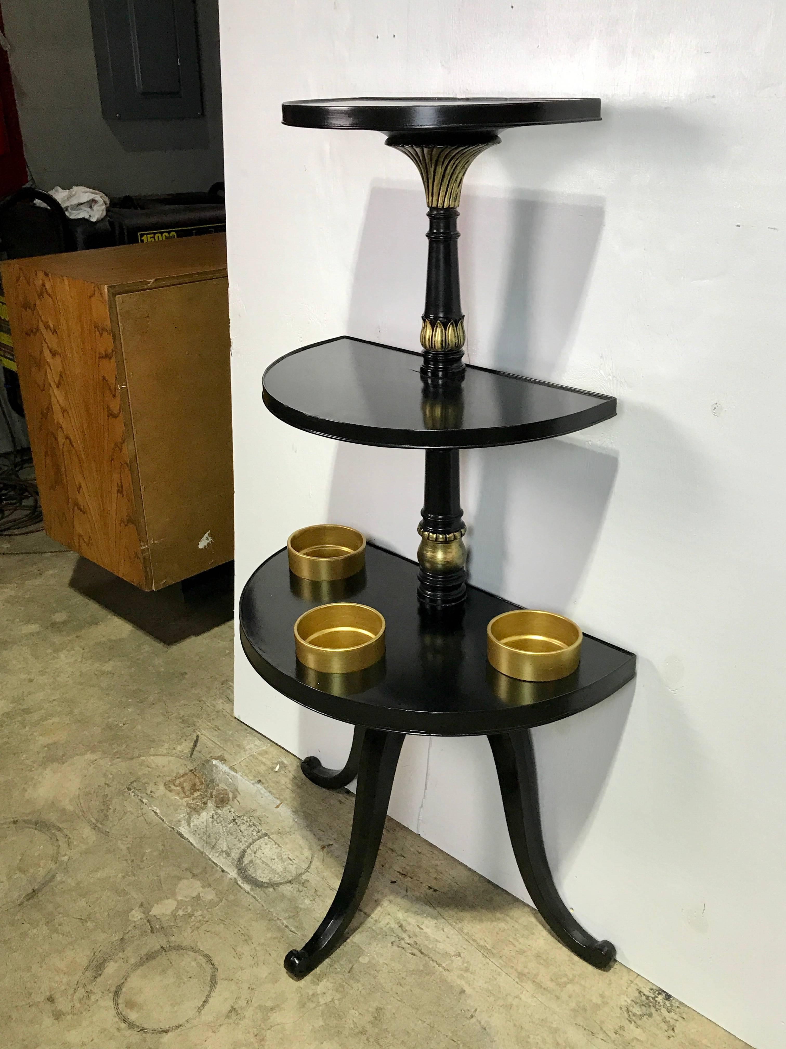 Maison Jansen style black lacquered and gilt plant stand, of demilune form fitted with three gilt 5-inch pots.
Top shelf measures 16