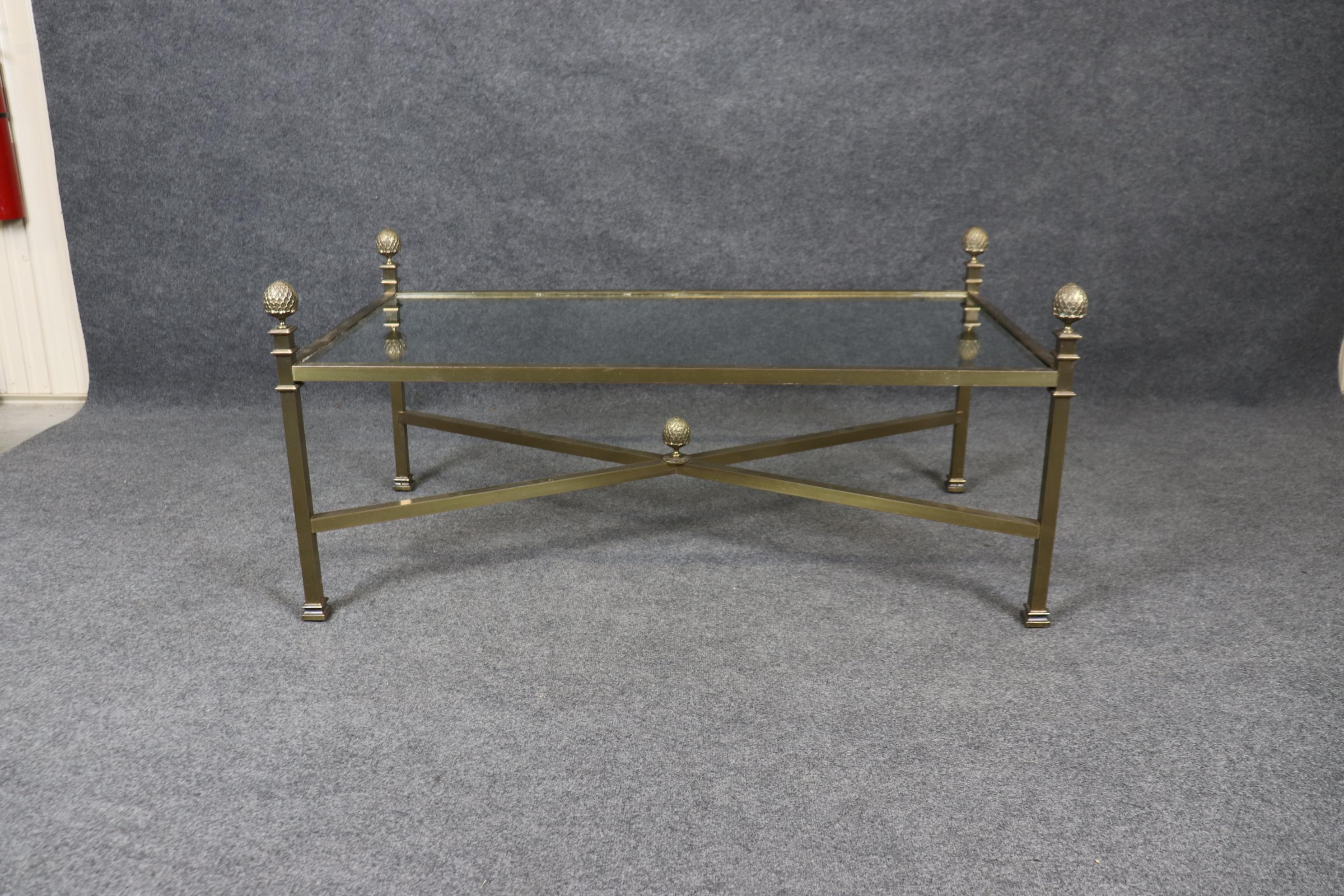 This is a gorgeous Maison Jansen style coffee table with a thick, bold brass boxed frame and fitted with beautiful carved 