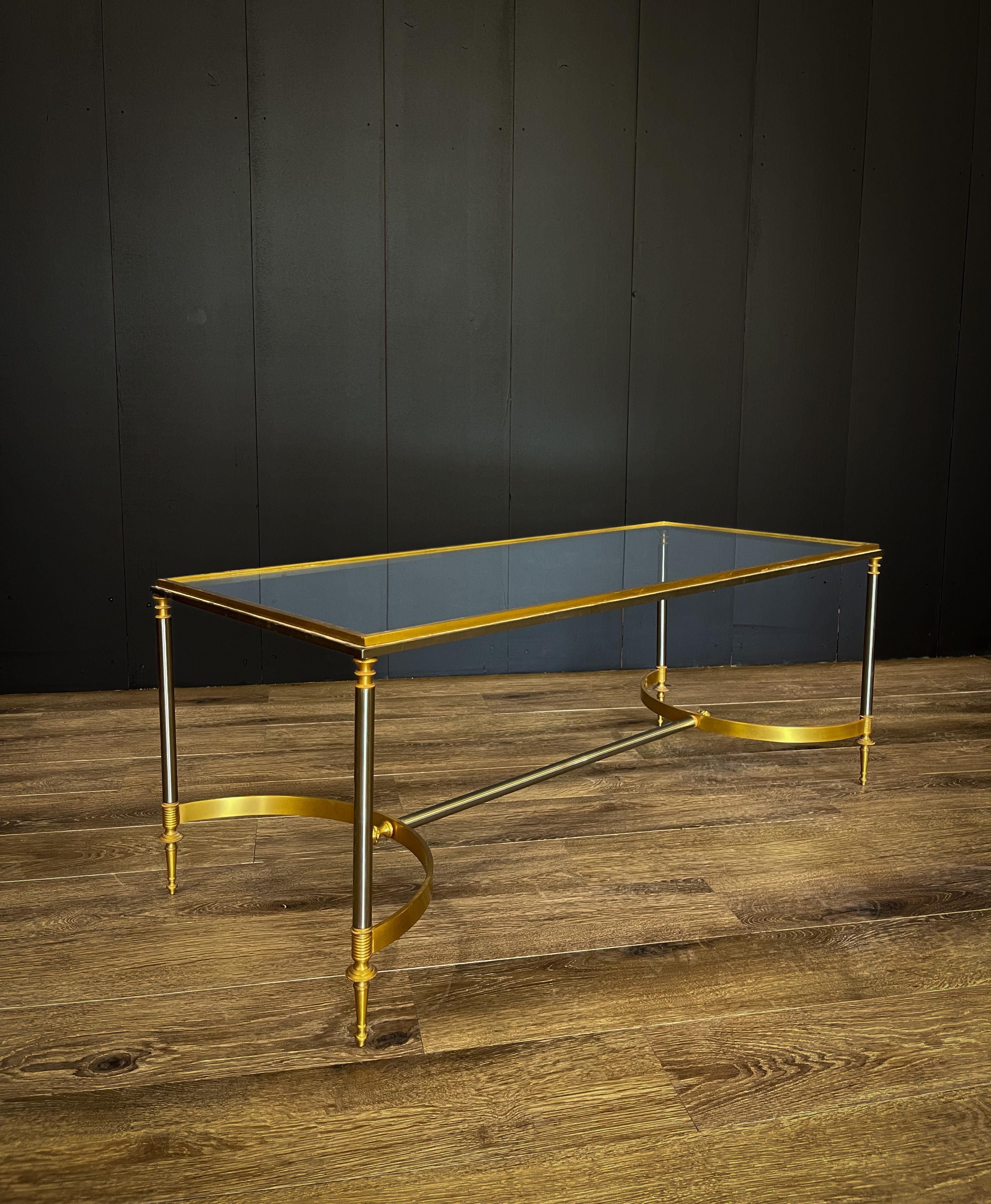 This beautiful Maison Jansen style Hollywood Regency coffee table oozes elegance with its golden brass curves and spindle foot and acorn detailing. Satin nickel legs finish this stunning piece.

42” L x 18” D x 16.5” T

Condition-minor scuffs to