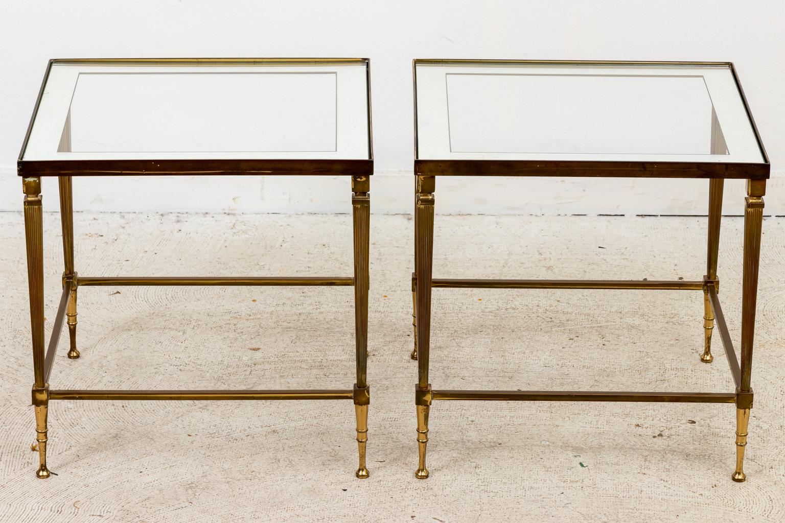 Circa 1980s Maison Jansen style brass cocktail table with a pair of nesting tables underneath. The tables feature a glass top with mirrored, etched band. Please note of wear consistent with age.