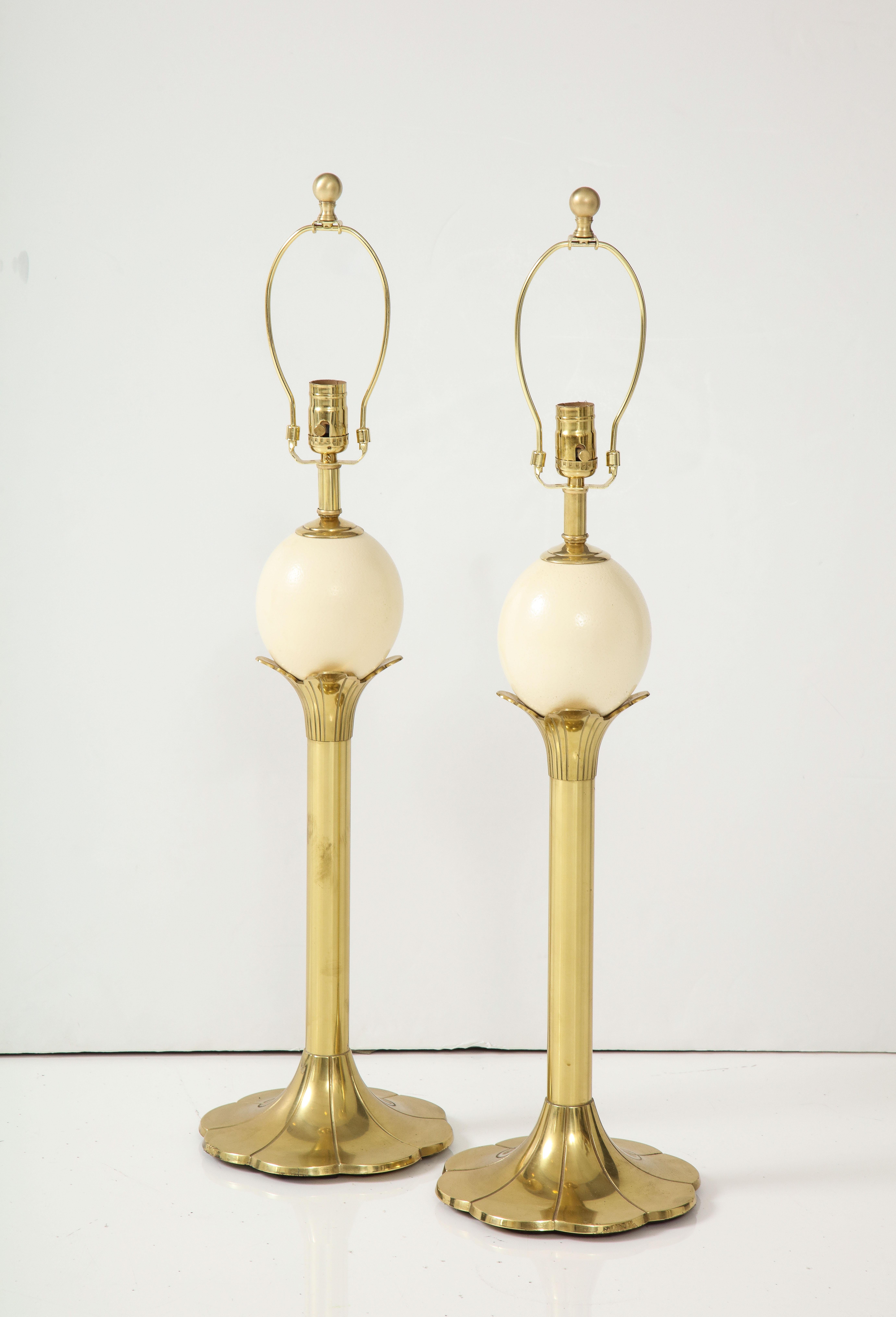 Pair of brass stylized palm tree form lamps topped with a genuine ostrich egg. Rewired for use in the USA, 100W max.
