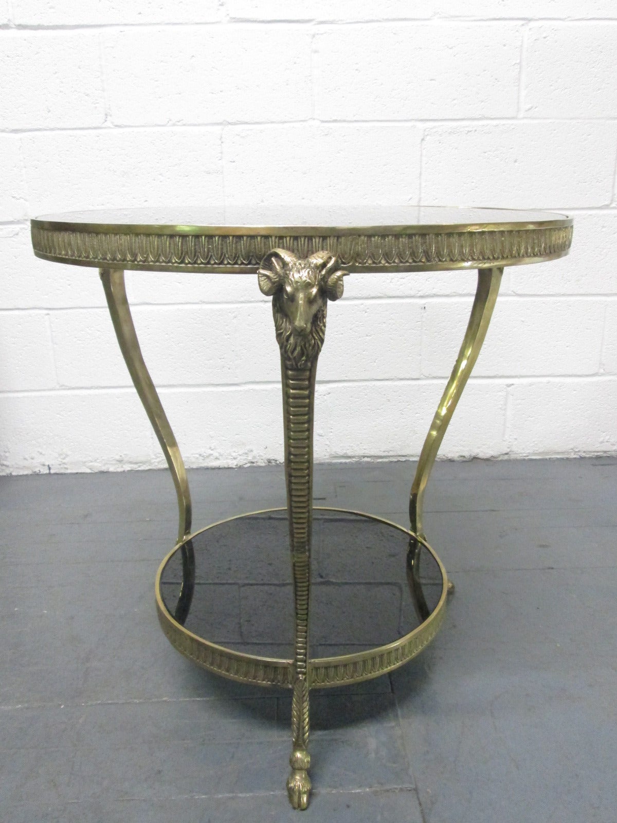 Brass ram's head Maison Jansen style two-tier side table, smoked glass top.
