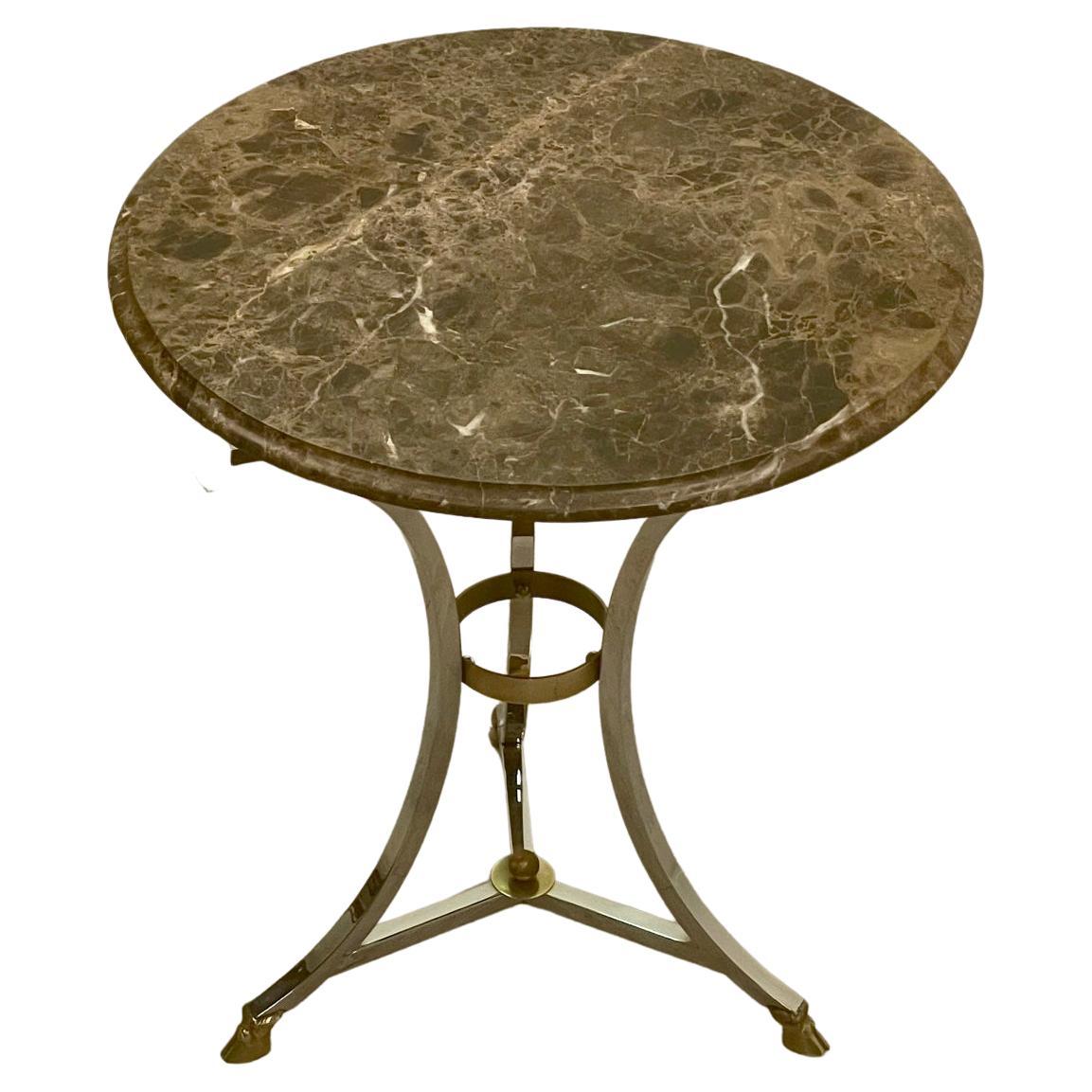 Classically elegant round Gueridon side table in the style of Maison Jansen having a mix of brass and chrome with hoof feet and a 1