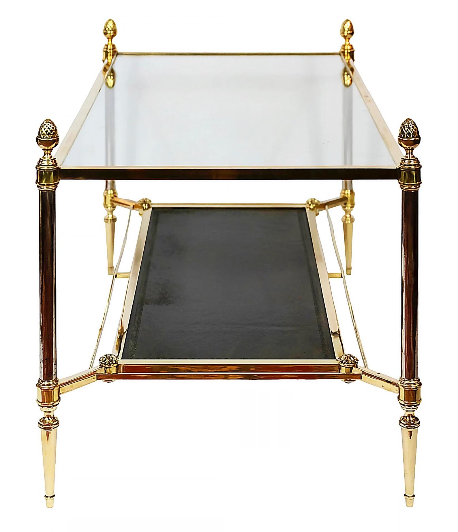 Table basse française à deux niveaux en laiton. La surface en verre est insérée dans un cadre en laiton avec des fleurons en laiton moulé en forme de gland. L'étage inférieur a une surface en cuir. Conçu par la Maison Jansen, Circa 1960.

Les