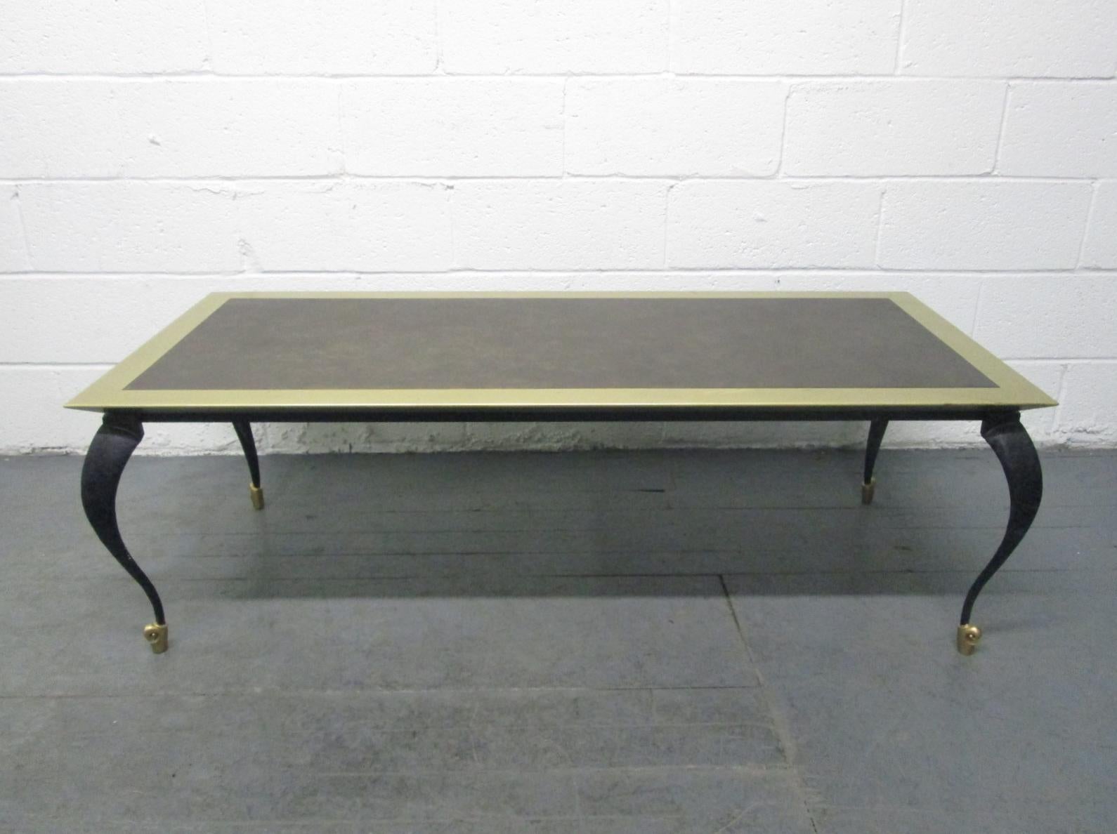 Table is mixed metal. The legs are iron, brass feet, brass and trim to the top.