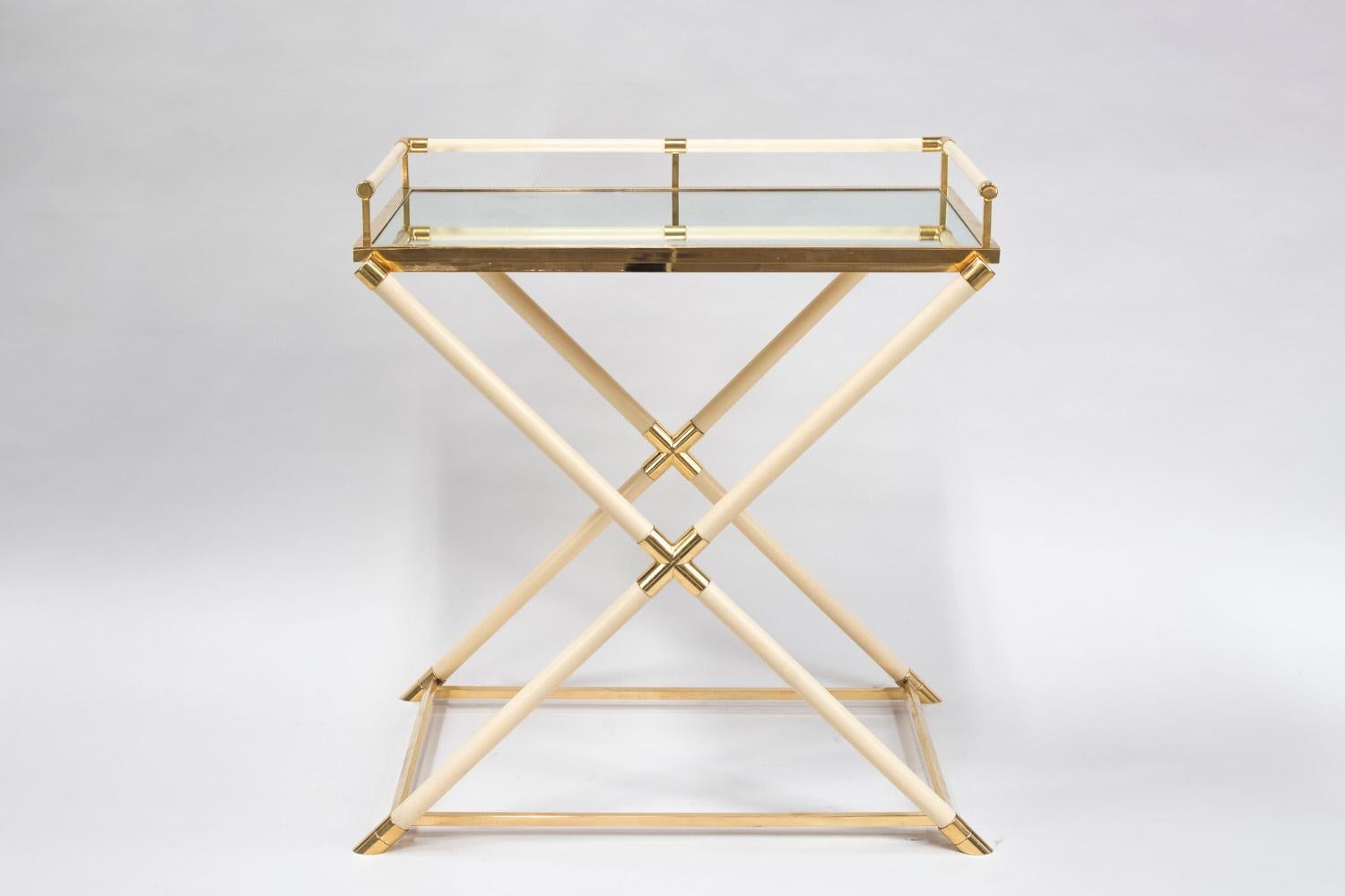Consulat style dessert table in cream bakelite with a X shaped stand topped by a removable tray with a mirror background and bakelite uprights on three sides in four. The frame under the tray, elbows, uprights endings and legs, stretchers are in