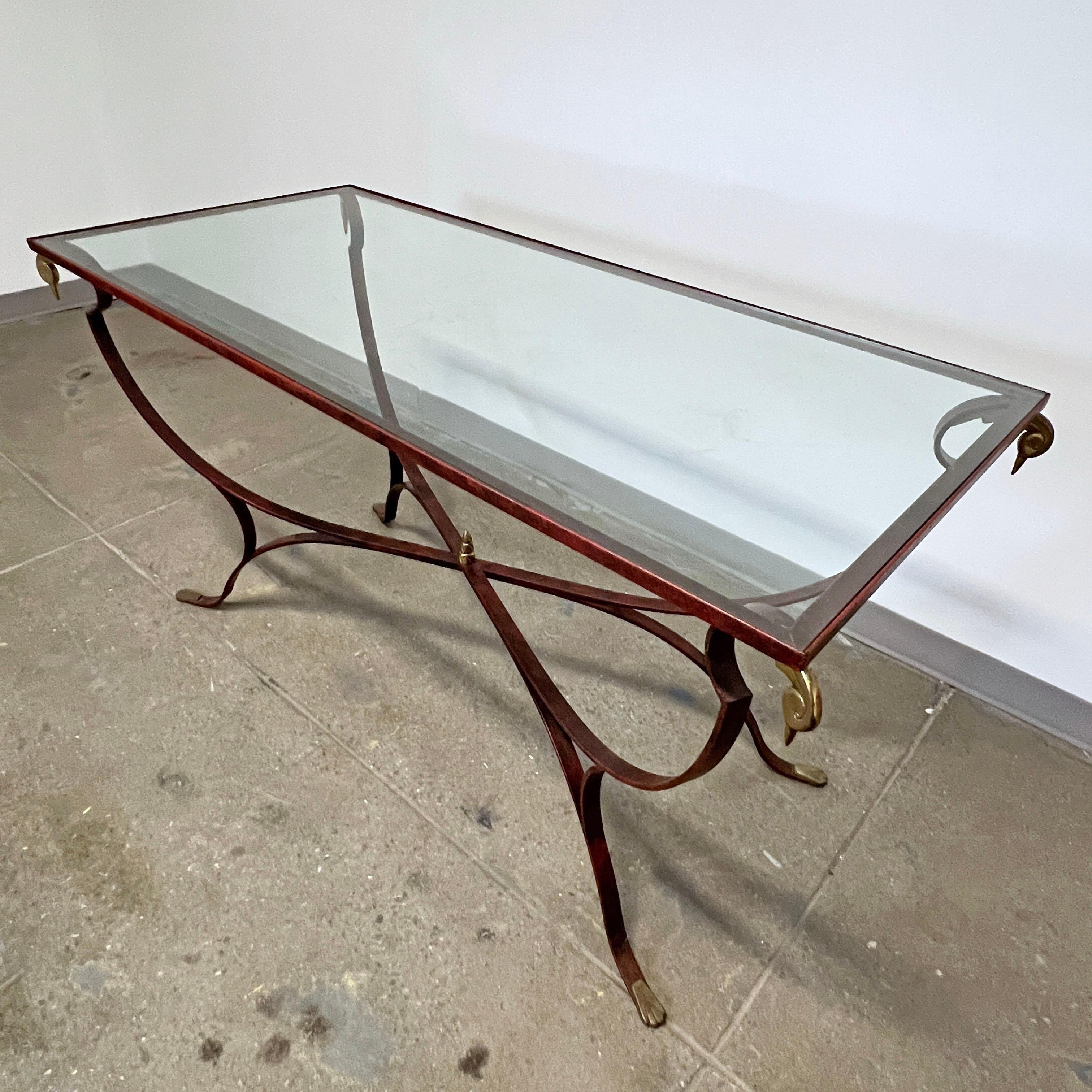 Table art déco française, de style Maison Jansen, en fer forgé laqué rouge avec des ornements d'angle en bronze représentant un cygne stylisé.

Voir notre liste séparée pour les chaises correspondantes.
