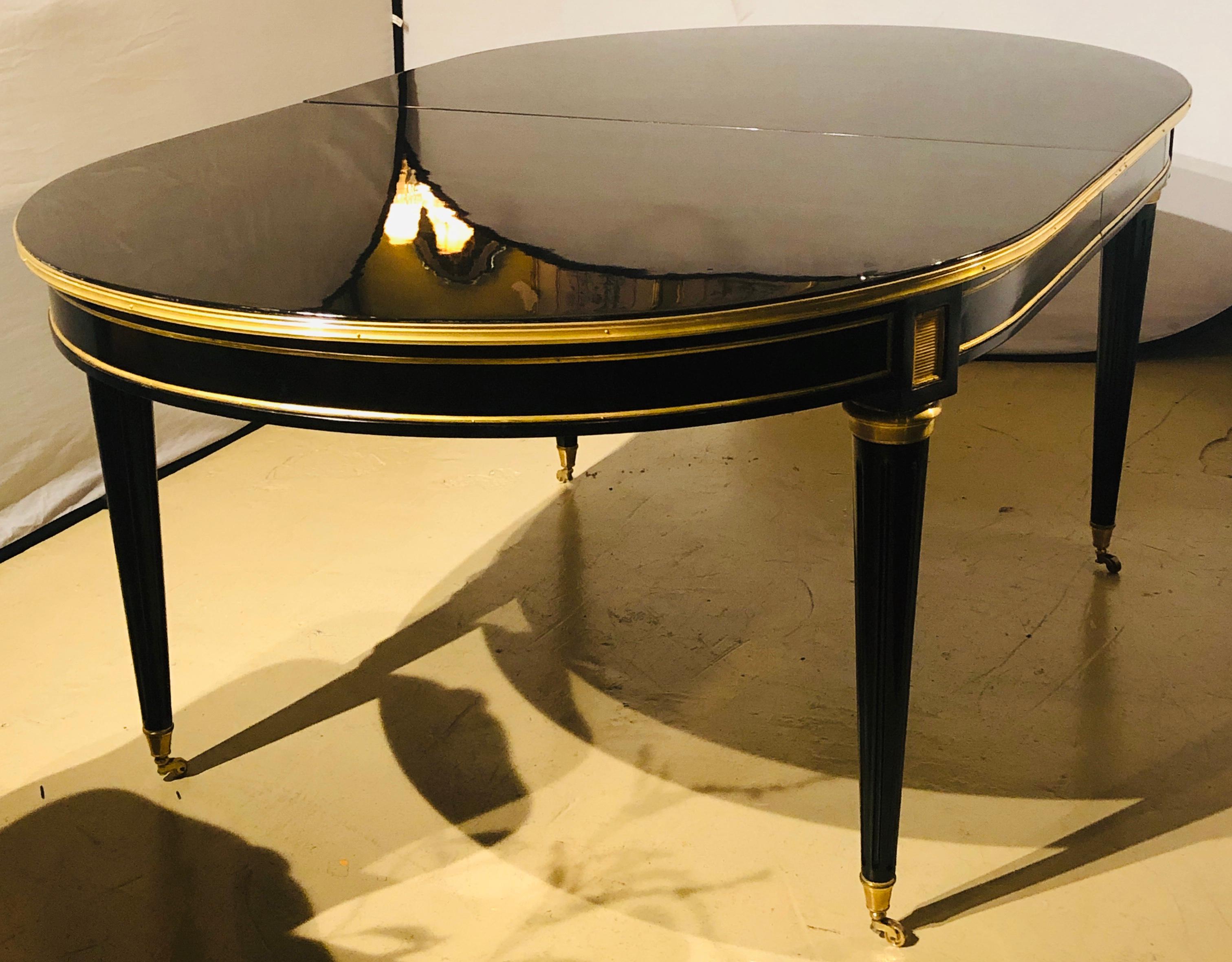 Maison Jansen style ebony lacquered dining table in Hollywood Regency fashion having three leaves measuring 15.5 inches each in stunning condition. This fine dining table certain to shine in any setting.
An ebony Maison Jansen style ten plus foot